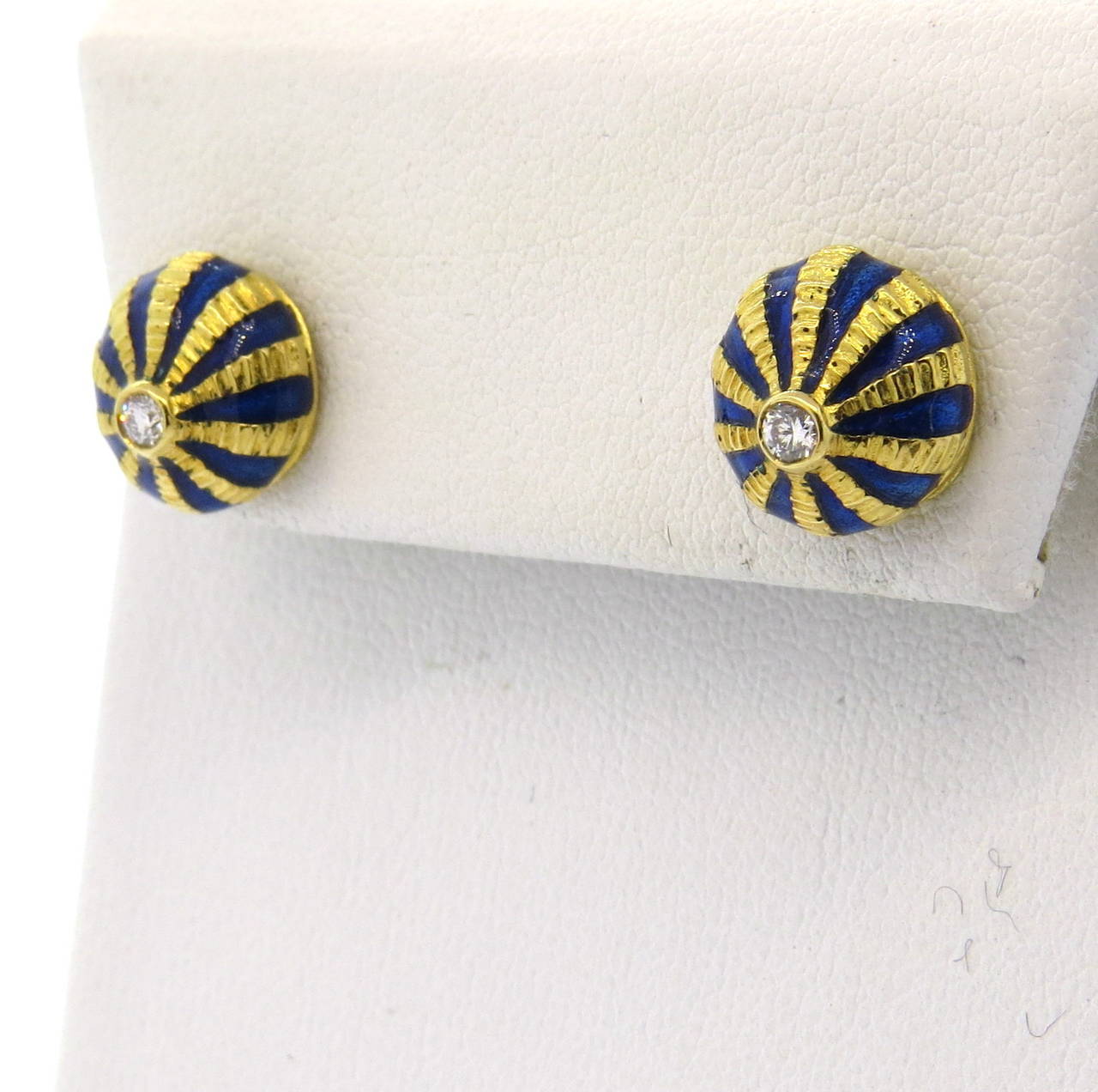 A pair of 18k yellow gold earrings adorned with blue enamel and two G/VS diamonds approximately 0.10ctw.  Crafted by Jean Schlumberger for Tiffany & Co., the earrings measure 10mm in diameter and weigh 6.8 grams.