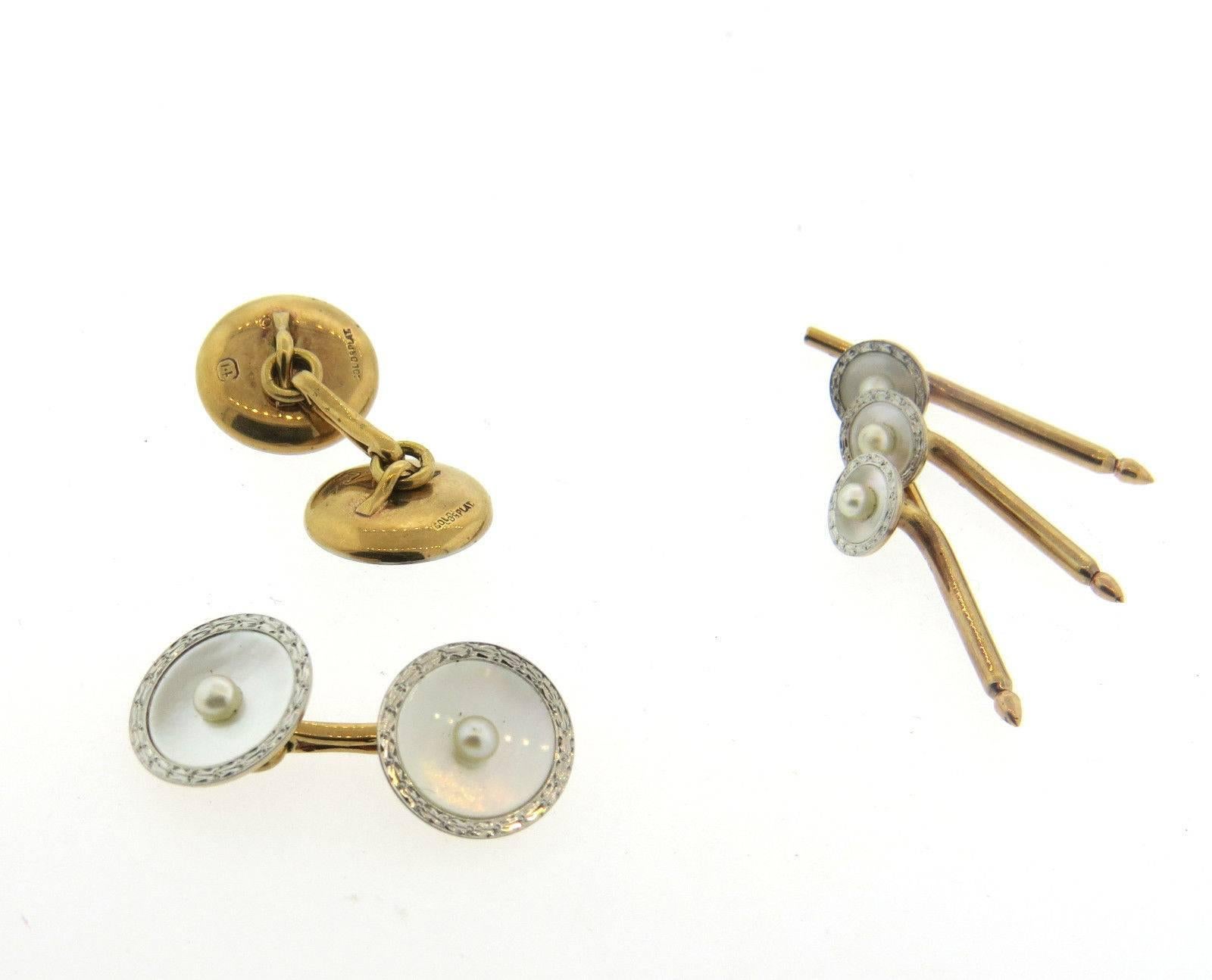 A set of 14k gold and platinum cufflinks and stud set adorned with pearls. Cufflink tops measure 14mm in diameter, and the stud tops are 8mm in diameter.  Marked: 14k, gold, plat.  The weight of the set is 12 grams.