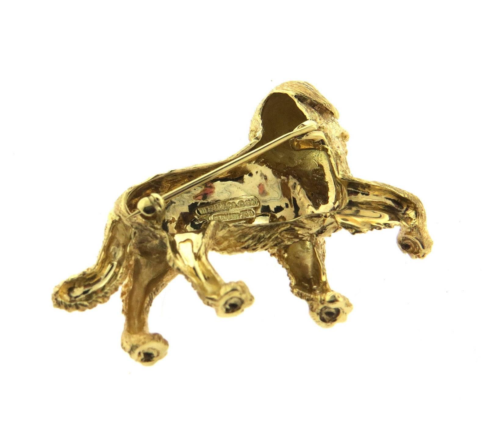 An 18k yellow gold dog brooch pin set with a 0.01ct G/VS diamond, and sapphires in the eyes.  Crafted by Tiffany, the brooch is 49mm x 35mm.  Marked: Tiffany & Co, 1991, 750, Germany.  The weight of the piece is 27.3 grams.