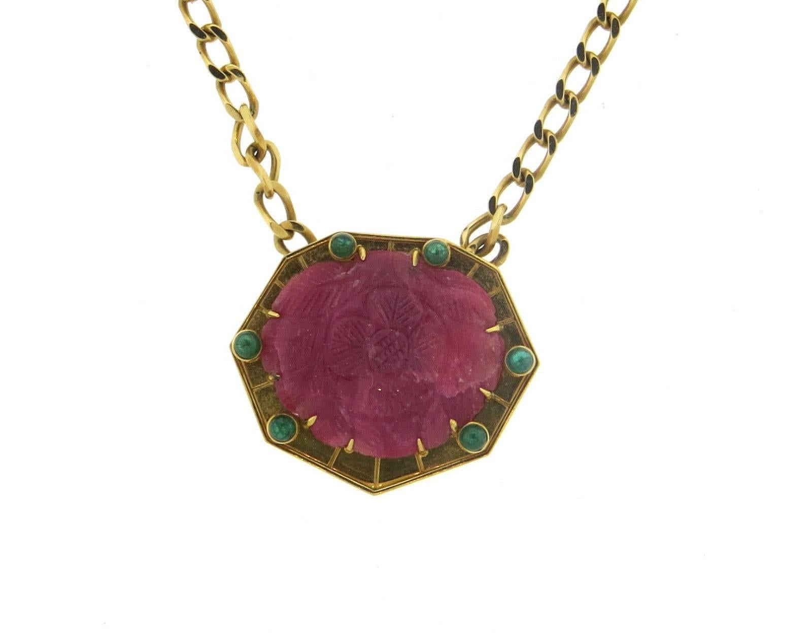 An 18k yellow gold necklace set with a carved ruby and emeralds. Created by David Webb, the necklace is 16 1/2