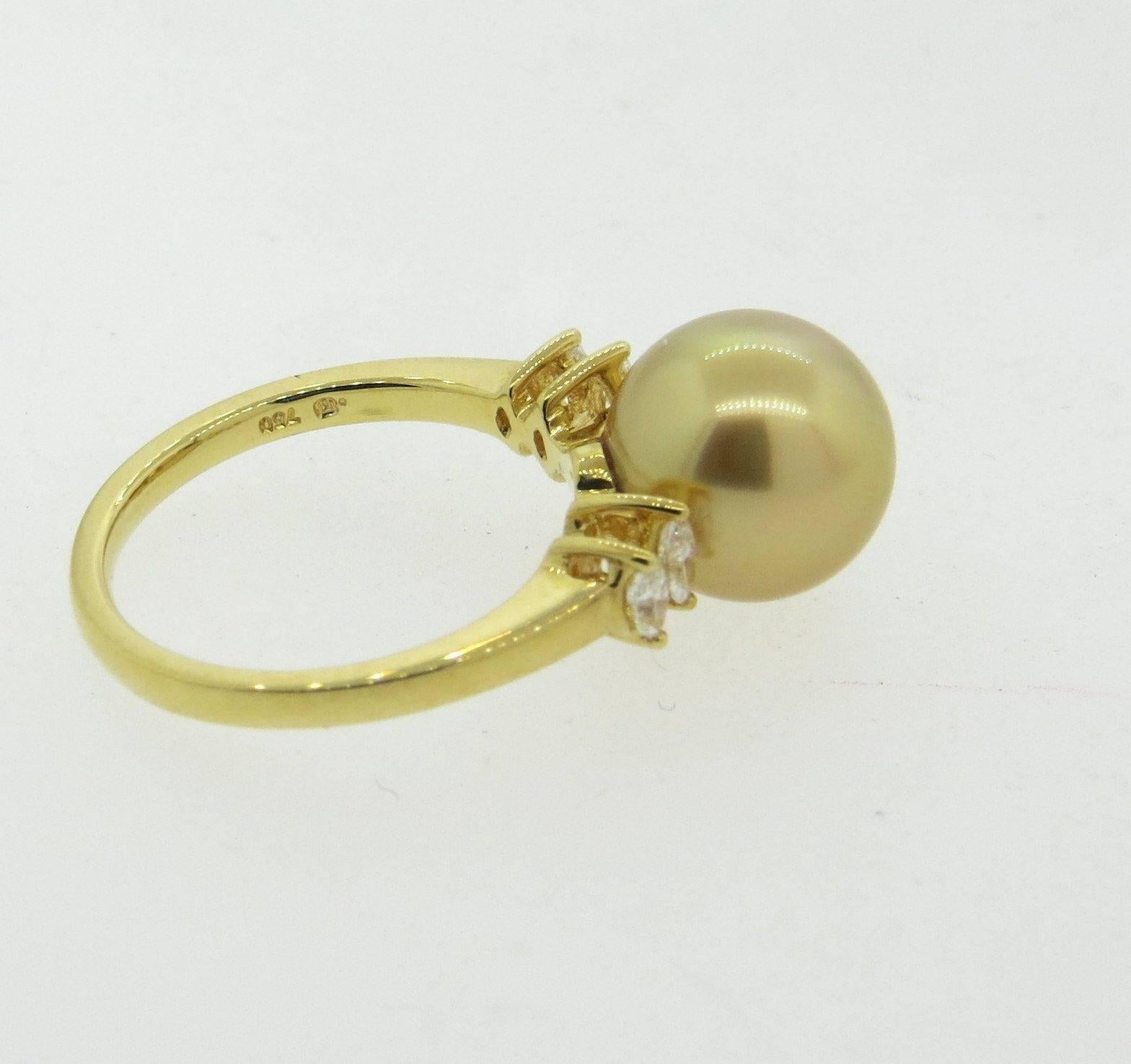 An 18k yellow gold ring set with a 10.8mm golden South Sea pearl and approximately 0.30ctw of G/VS diamonds.  Crafted by Mikimoto, the ring is a size 6 1/2.  Marked:	M hallmark, 750.  The weight of the ring is 5.1 grams.