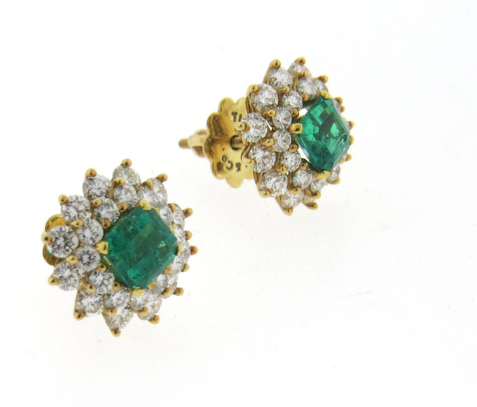 A pair of 18k yellow gold earrings set with approximately 2 carats of G/VS diamonds and emeralds measuring 5.9mm x 5.5mm.  Crafted by Tiffany & Co., the earrings measure 13mm x 12.5mm and weigh 5.6 grams. Marked: Tiffany & Co, 18k