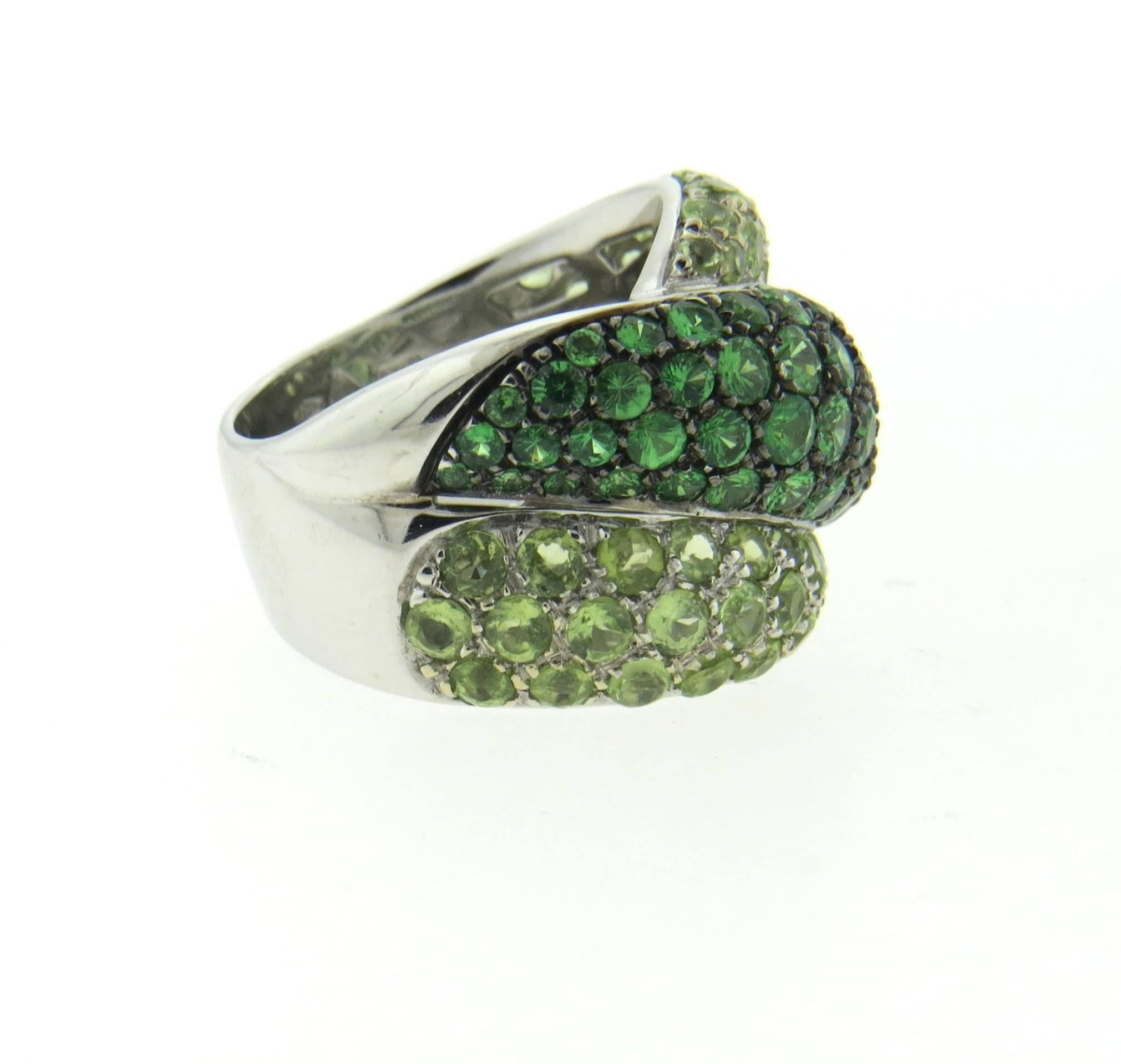 New 18k white gold ring, crafted by Damiani, decorated with lighter and darker green sapphires. Ring size - 7 1/4, ring is 16mm wide. Marked: Damiani, made in Italy, 05/85. Weight of the ring - 15.2 grams
Retail $12350