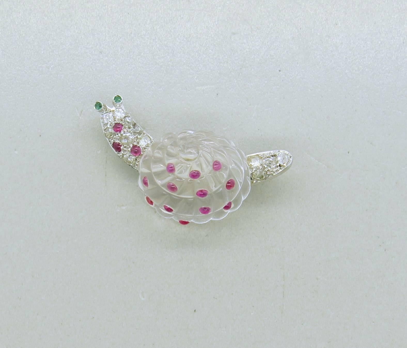 Adorable platinum snail brooch, decorated with carved rock crystal, set with ruby cabochons and old mine cut diamonds, with emerald eyes.Brooch measures 40mm x 17mm. Weight of the piece - 14.2 grams 