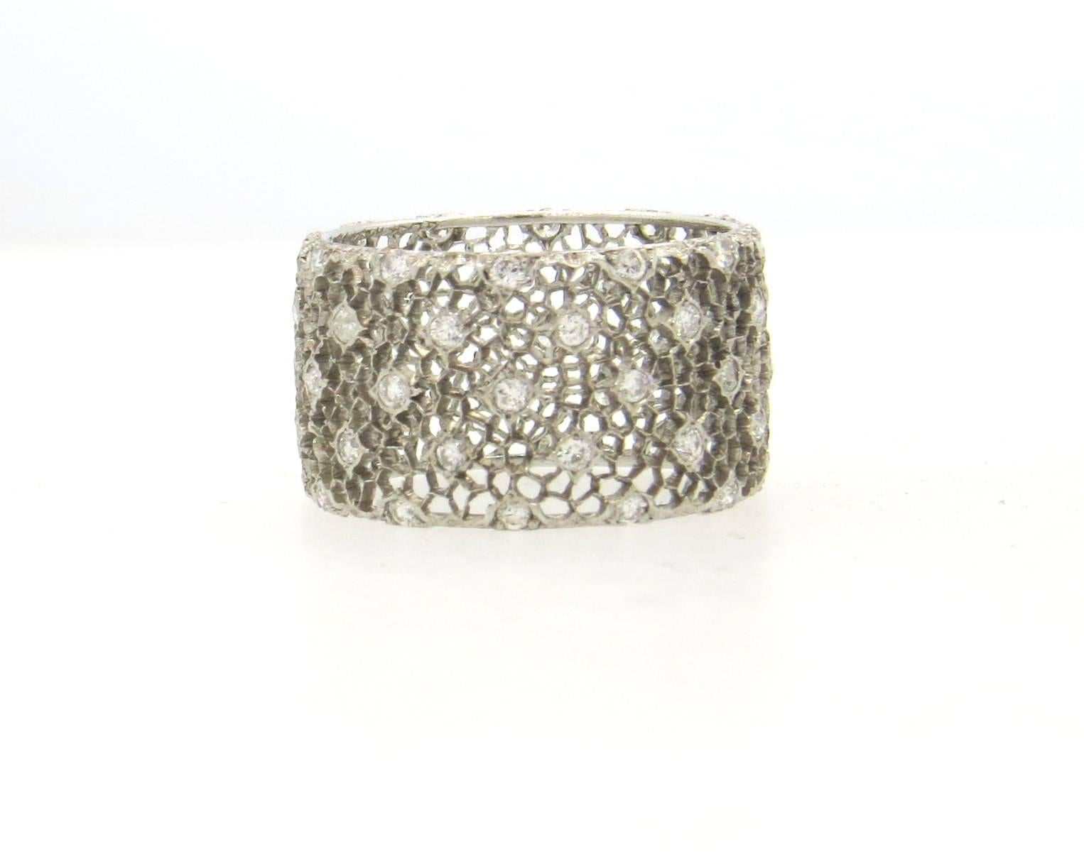 Wide 18k white gold wedding band, crafted by Buccellati, featyuring honeycomb lace design, decorated with approximately 0.60ctw in H/VS diamonds. Ring size  6 1/4, ring is 11.5mm wide. Marked: Buccellati 18k. Weight of the piece - 3.2 grams
