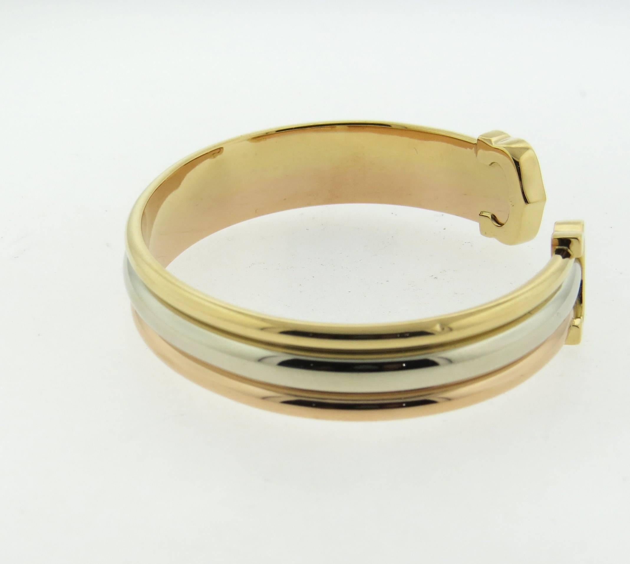 Classic Trinity 18k tri color gold open cuff bracelet, crafted by Cartier, featuring two C's. Bracelet will fit up to 7
