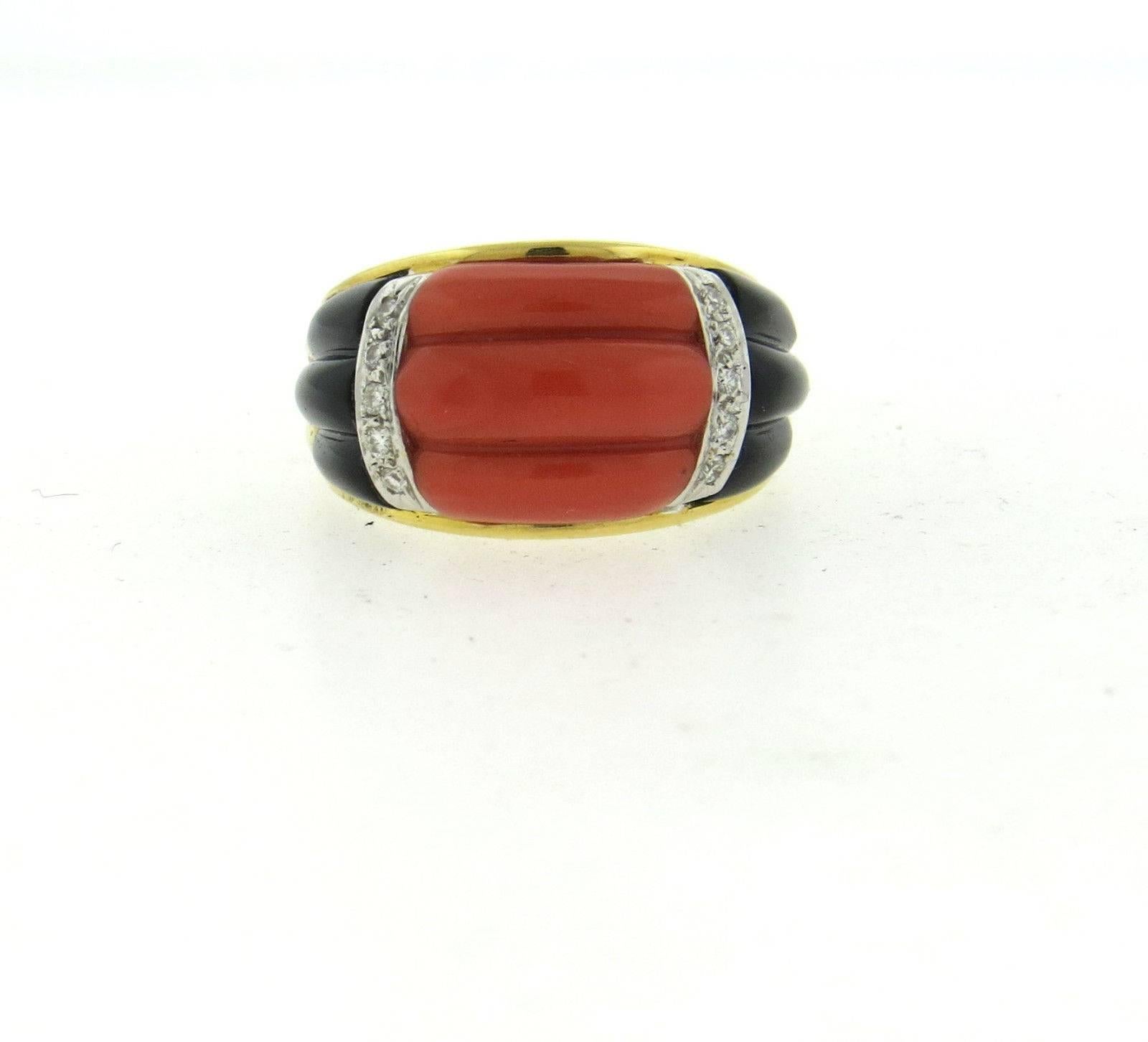 An 18k yellow gold ring adorned with carved coral and onyx and accented by approximately 0.10ctw of H/VS-SI diamonds.  The ring is a size 7 1/2 and 13mm wide. 