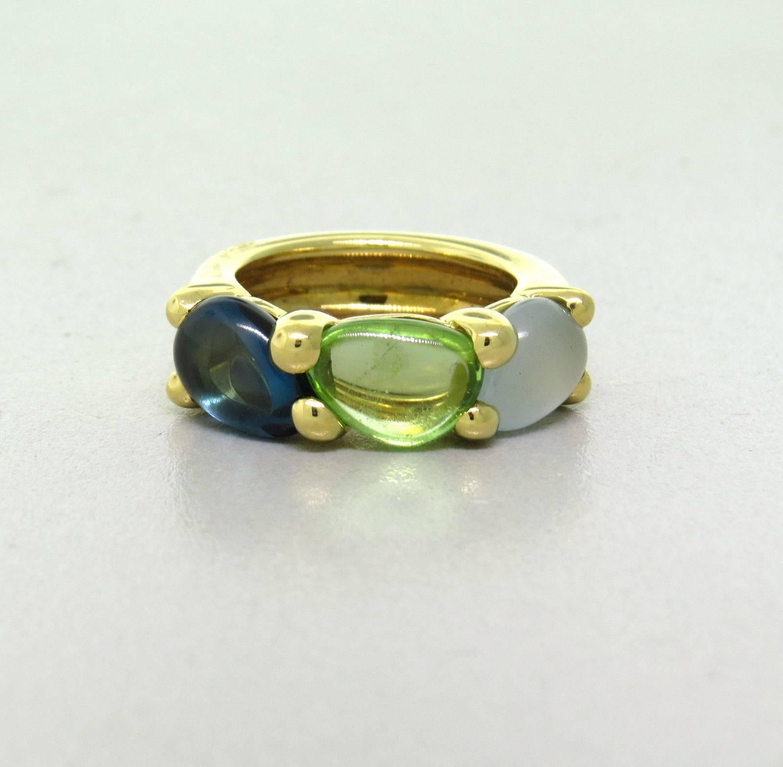 An 18k yellow gold ring, crafted by Pomellato for Sassi collection, decorated with blue topaz, peridot and aquamarine gemstones. Ring size  6, ring is 8mm wide.  Weight - 13 grams 
