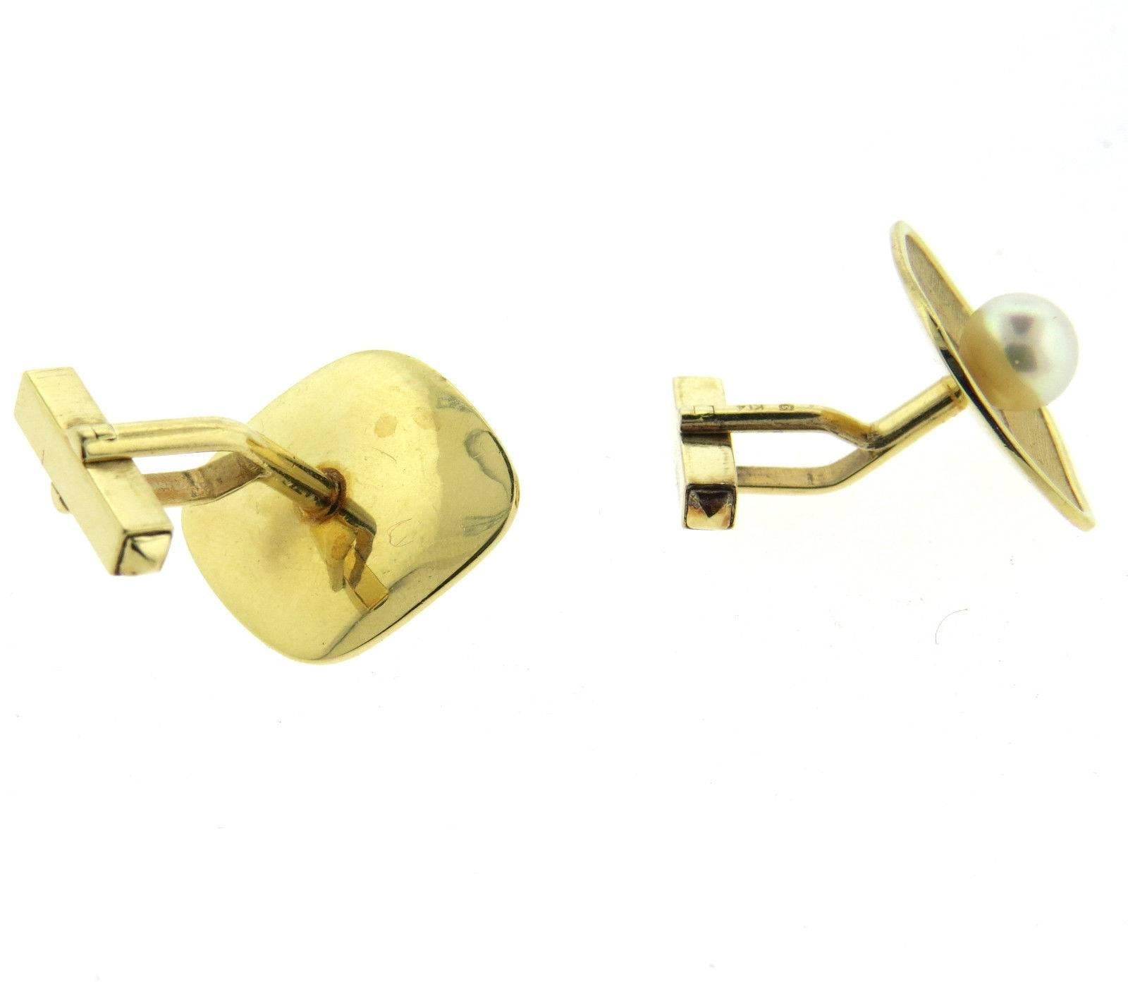 A pair of 14k yellow gold cufflinks set with 7.3mm saltwater cultured pearls.  Crafted by Mikimoto, the cufflinks measure 23mm x 19mm and weigh 12.3 grams. Marked: k14, M hallmark.
