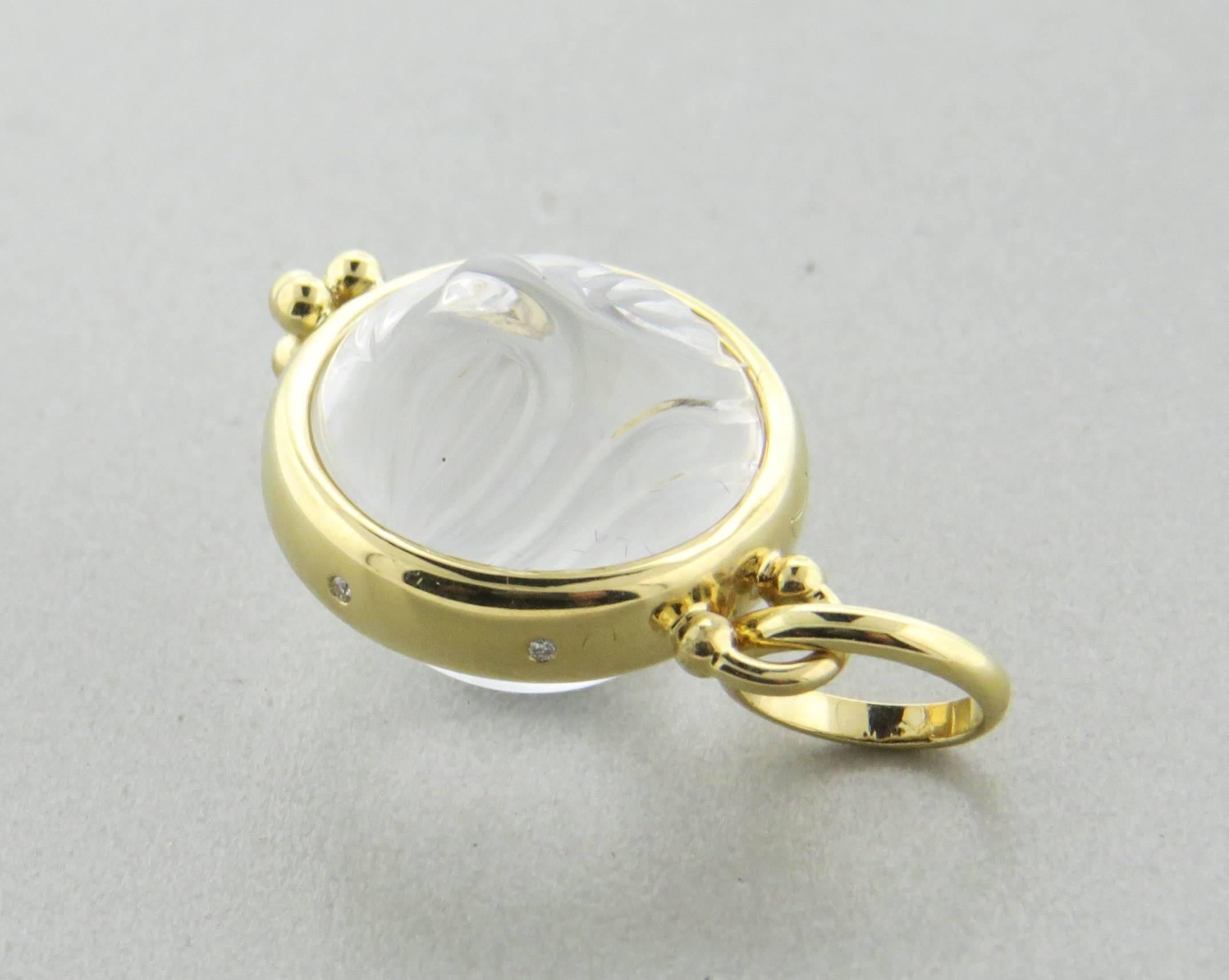 An 18k yellow gold pendant charm, crafted by Temple St. Clair, featuring carved 23ct crystal, depicting moonface, adorned with diamonds on sides. Pendant is 25mm long without bale x 18mm wide, with bale - 33mm long . Marked with Temple hallmark and