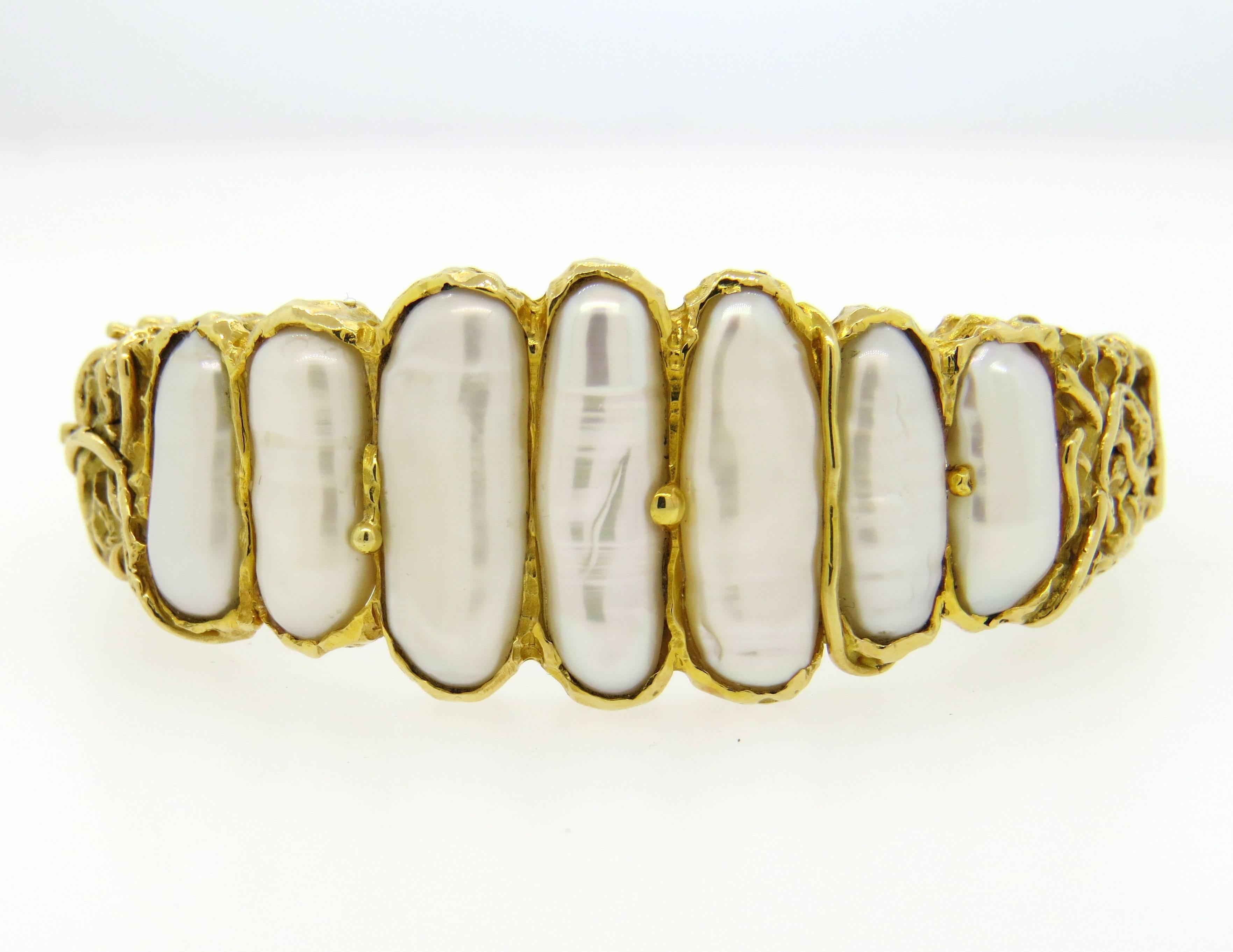 Elegant 18K Gold bracelet by Brinkhaus featuring graduated freshwater pearls in a naturalistic setting. Bracelet measures 25mm at widest point and will fit up to a 7