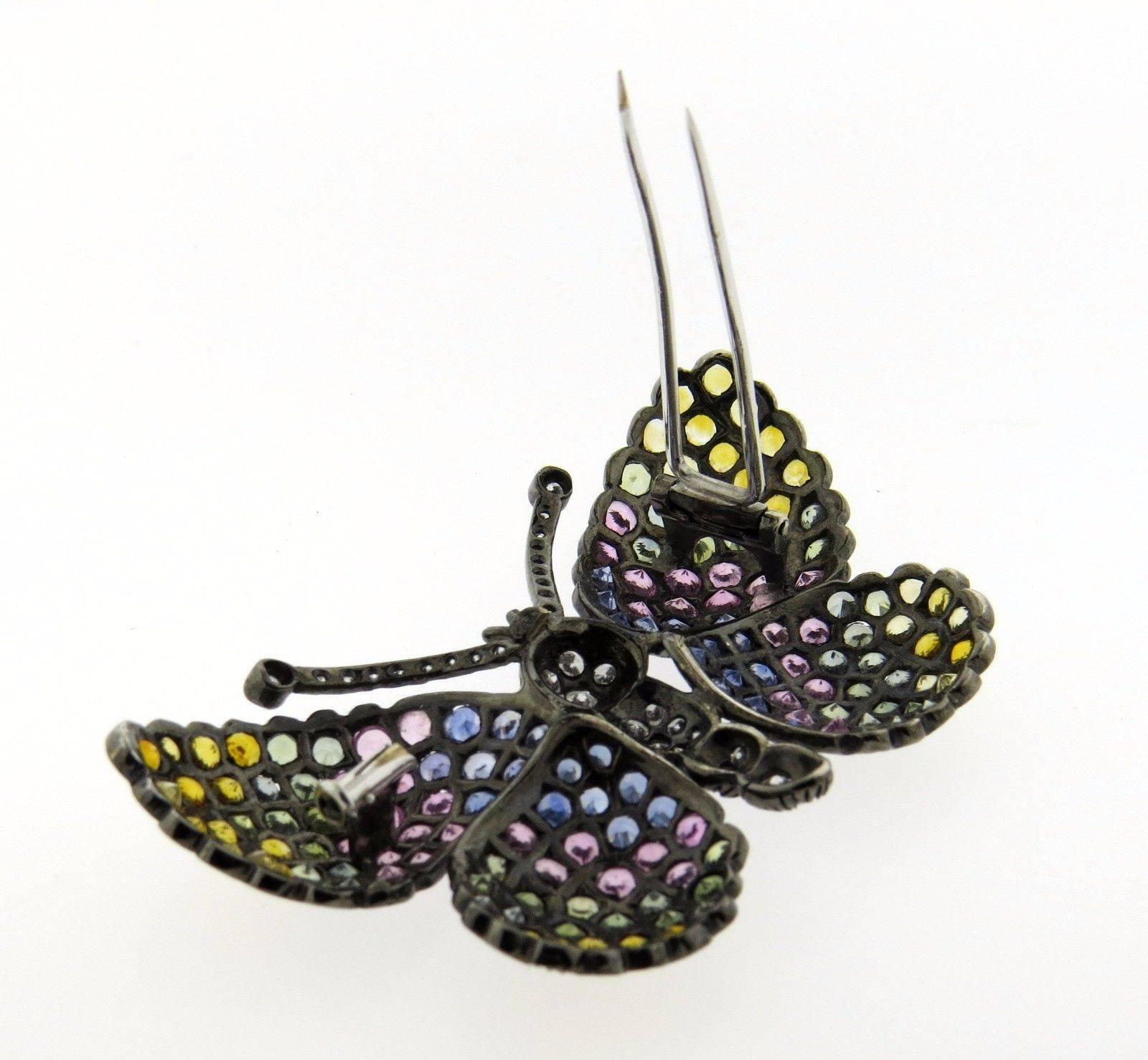 An 18k gold butterfly brooch set with approximately 1.10ctw of G-H/VS1-SI1 diamonds and multi color sapphires. The brooch measures 65mm x 41mm and weighs 24.8 grams.