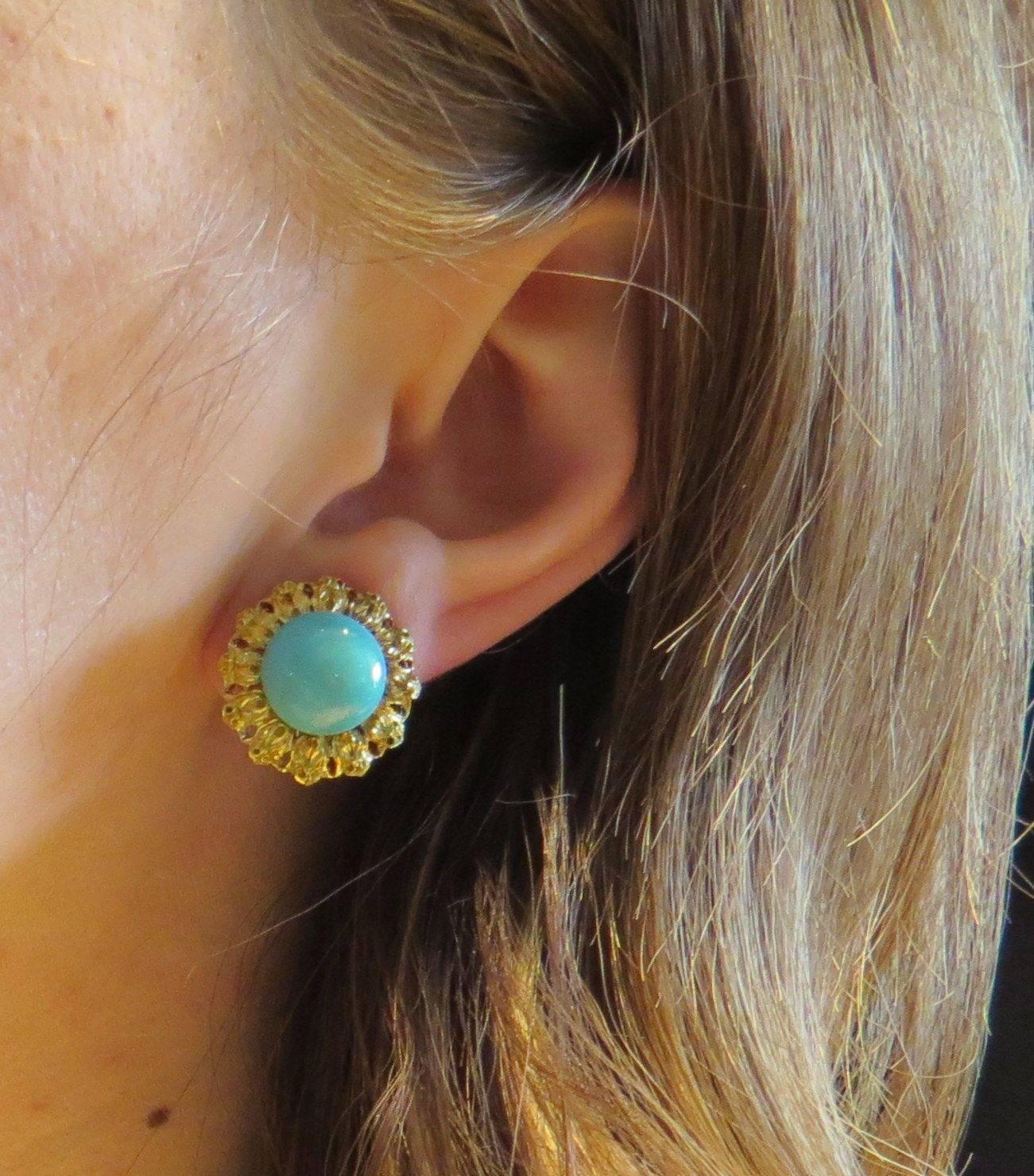 A pair of 18K yellow gold earrings set with 11.5mm turquoise.  Crafted by Buccellati, the earrings measure 18mm in diameter and weigh 12.1 grams.