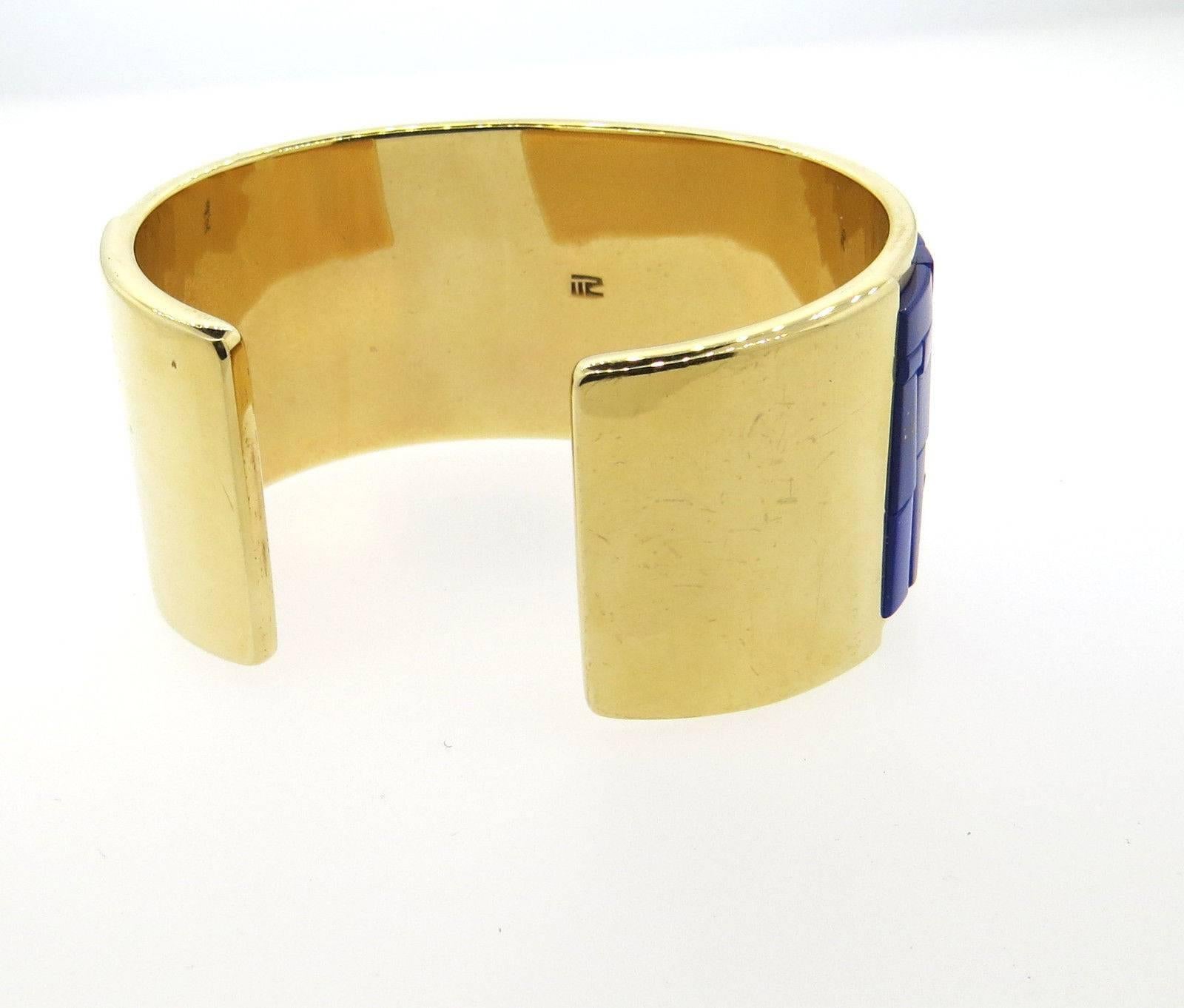 A 14k yellow gold bracelet set with lapis, coral and turquoise.  Crafted by Richard Chavez, the bracelet will fit up to a 6