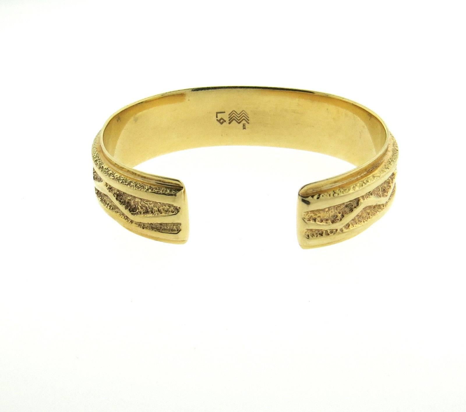 A 14k yellow gold cuff bracelet by Larry Golsh.  The bracelet will fit up to 6