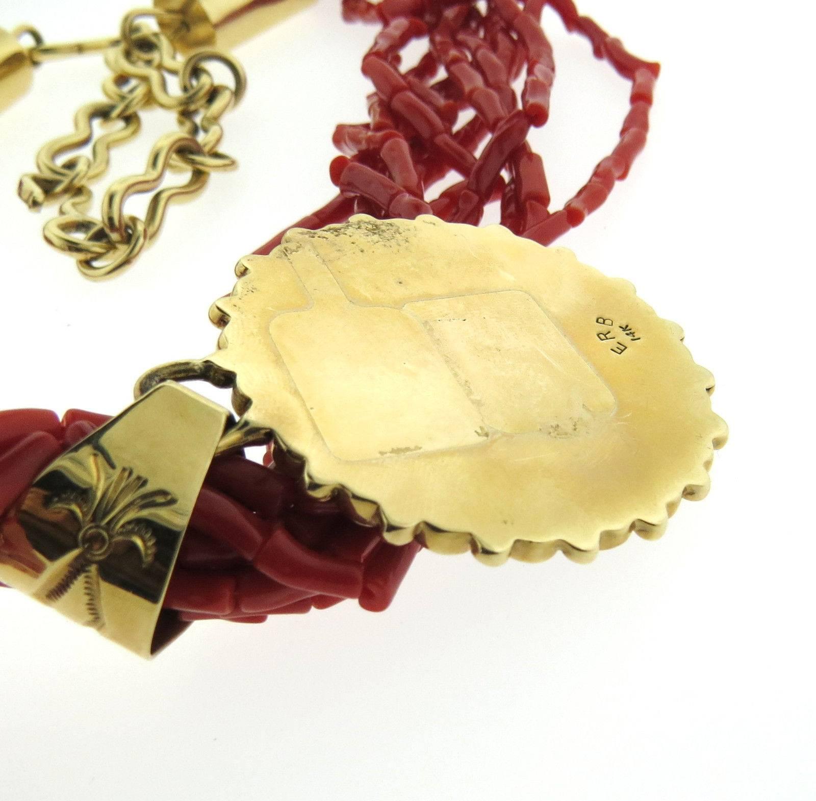 A 14k yellow gold necklace set with coral.  Crafted by Ernest Roy Begay, the necklace is 26