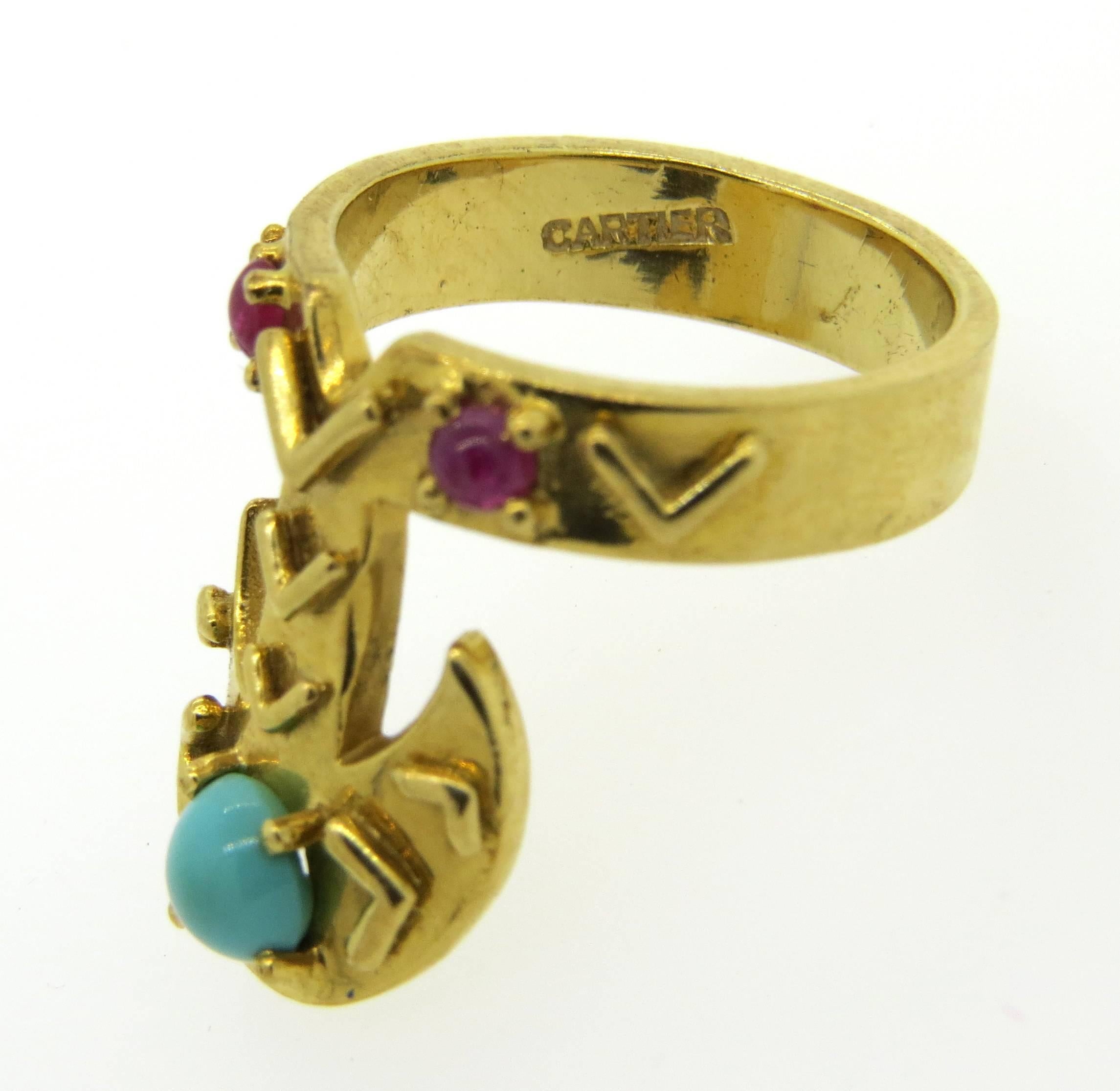 This whimsical ring by Cartier is crafted in 18K gold featuring turquoise and rubies. Ring size 6, top measures 20.5mm at widest point. Marked Cartier, 18K. Ring weighs 9.7 grams. 
