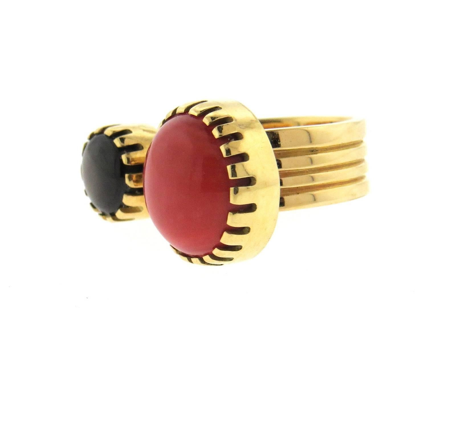 An 18k yellow gold ring set with coral and black sapphire.  The ring is a size 5 3/4, ring top is 14mm x 26mm. Marked with the maker's mark GY and 18k.  The weight of the ring is 12.7 grams.