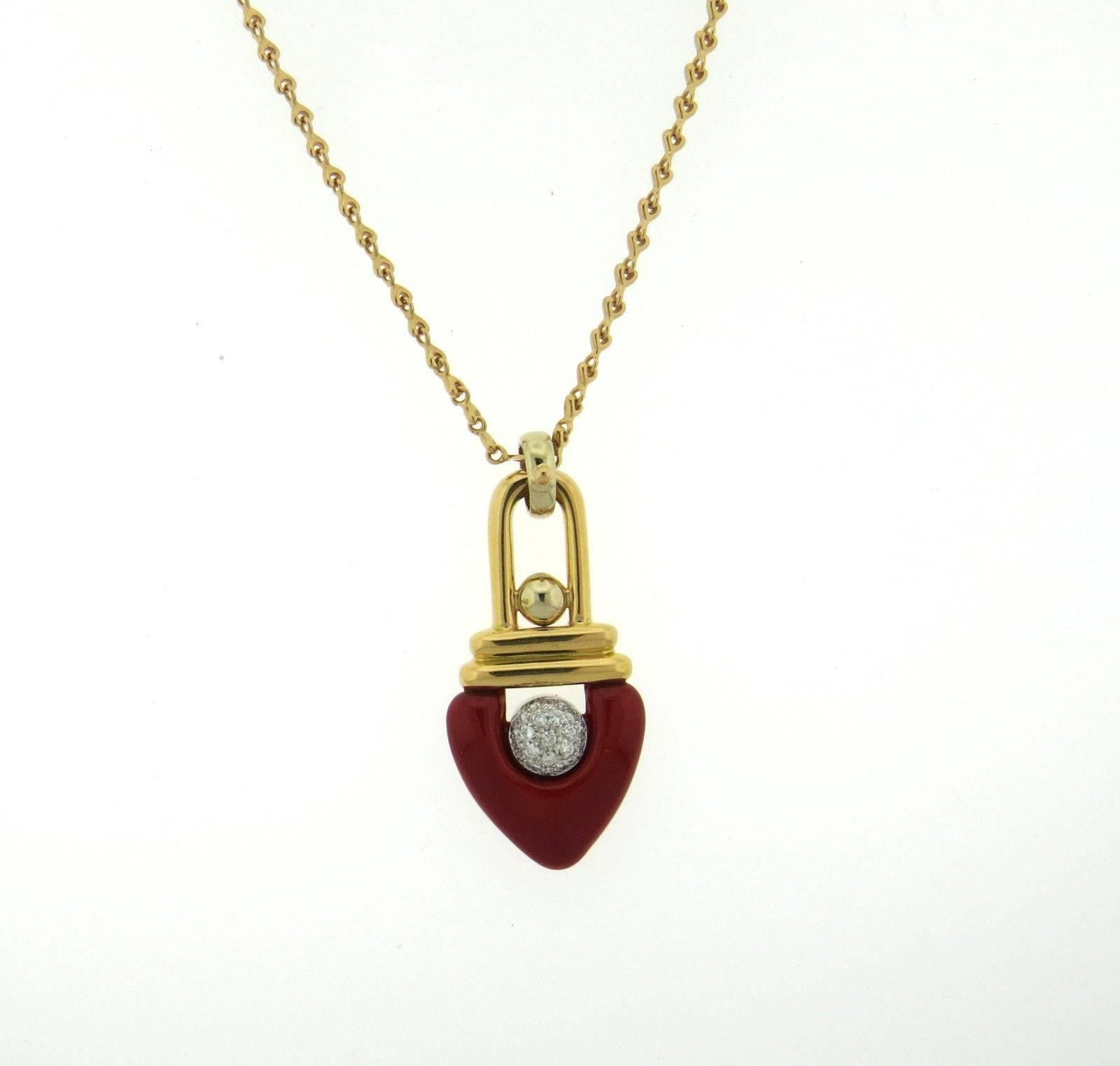 An 18k gold necklace adorned with a 0.22ctw diamond and red enamel pendant. The necklace is 35