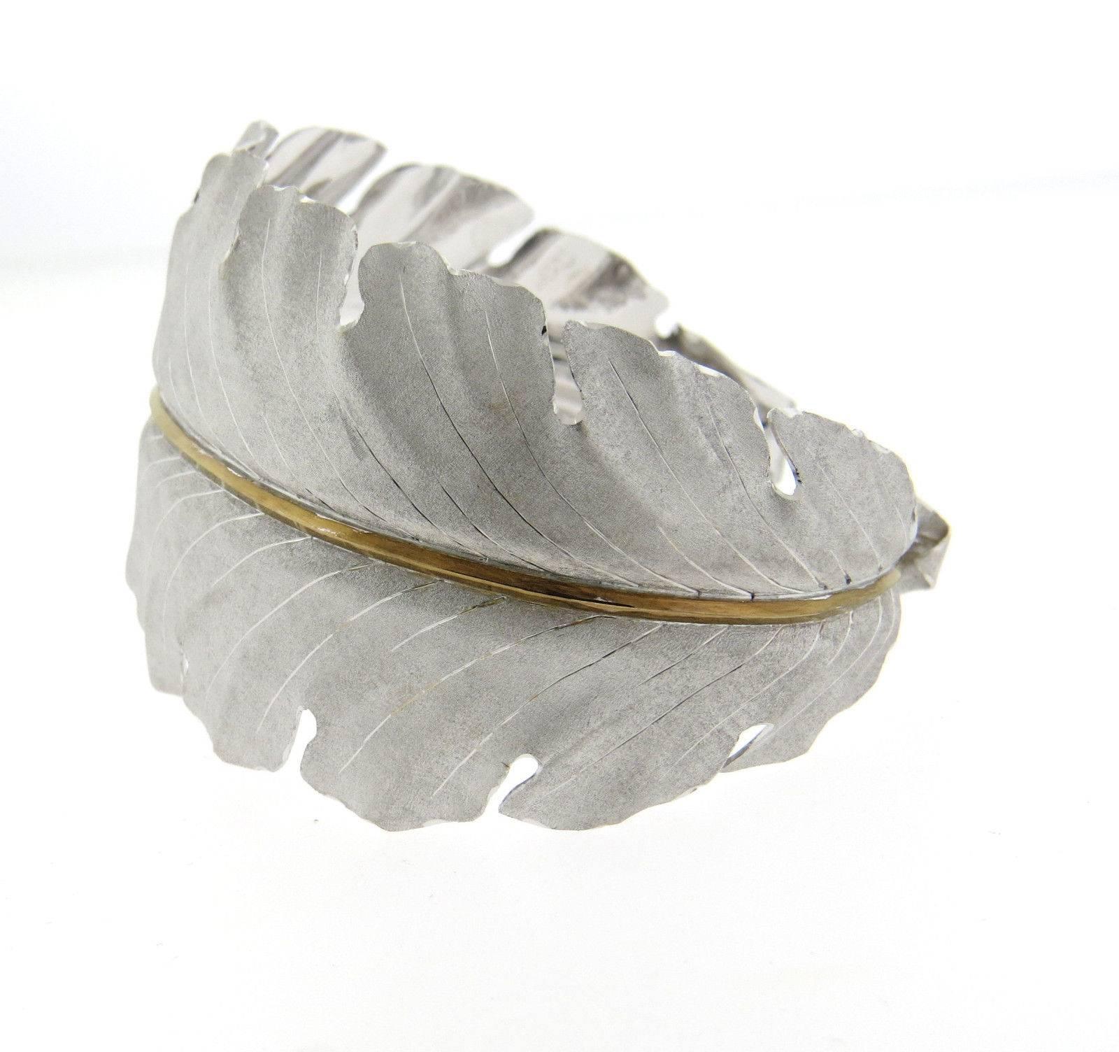 An 18k yellow gold and sterling silver leaf motif cuff bracelet.  Crafted by Buccellati, the bracelet will fit up to a 7