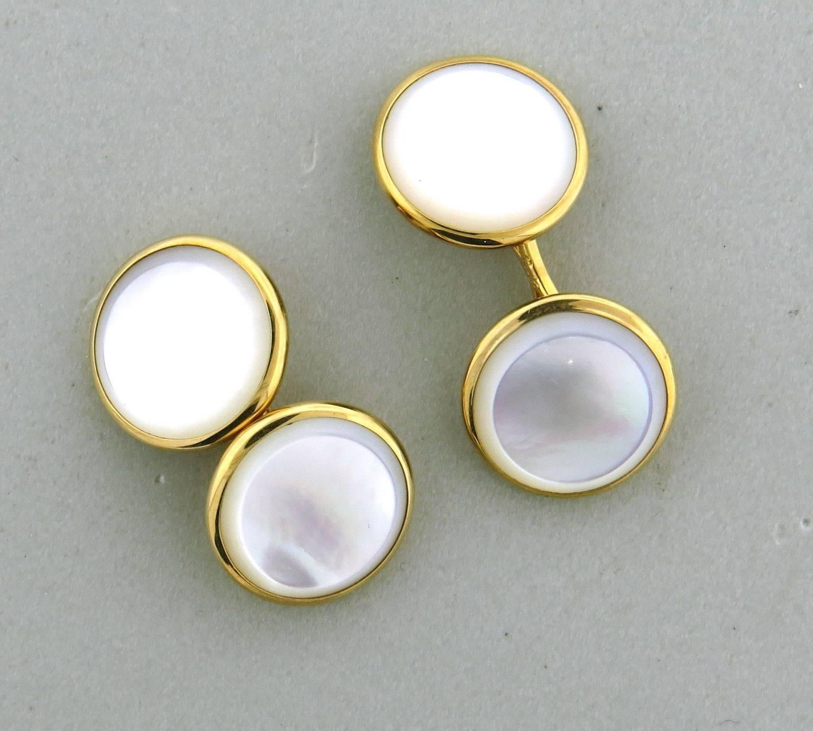 A set of 14k yellow gold cufflinks and studs adorned with mother of pearl.  Crafted by Brooks Brothers, the cufflinks measure 14mm in diameter, while the studs measure 8mm. Brooks Brothers, 14k.  The weight of the set is 9.5 grams.