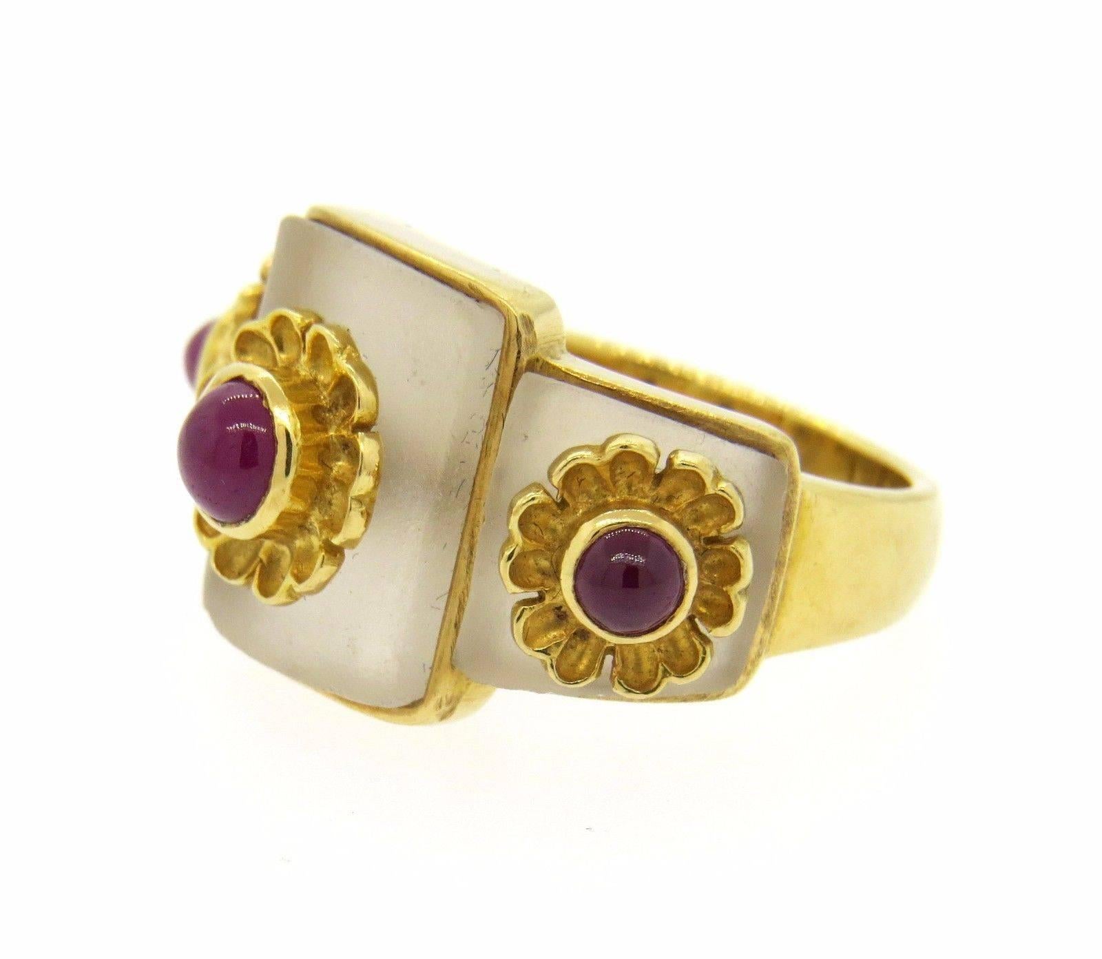 An 18k yellow gold ring set with frosted crystal and rubies.  Crafted by Ilias Lalaounis, the ring is a size 6.5, top measures 14mm at widest point. The weight of the ring is 9.9 grams.  Marked: Maker's Mark, 750, Greece, A21