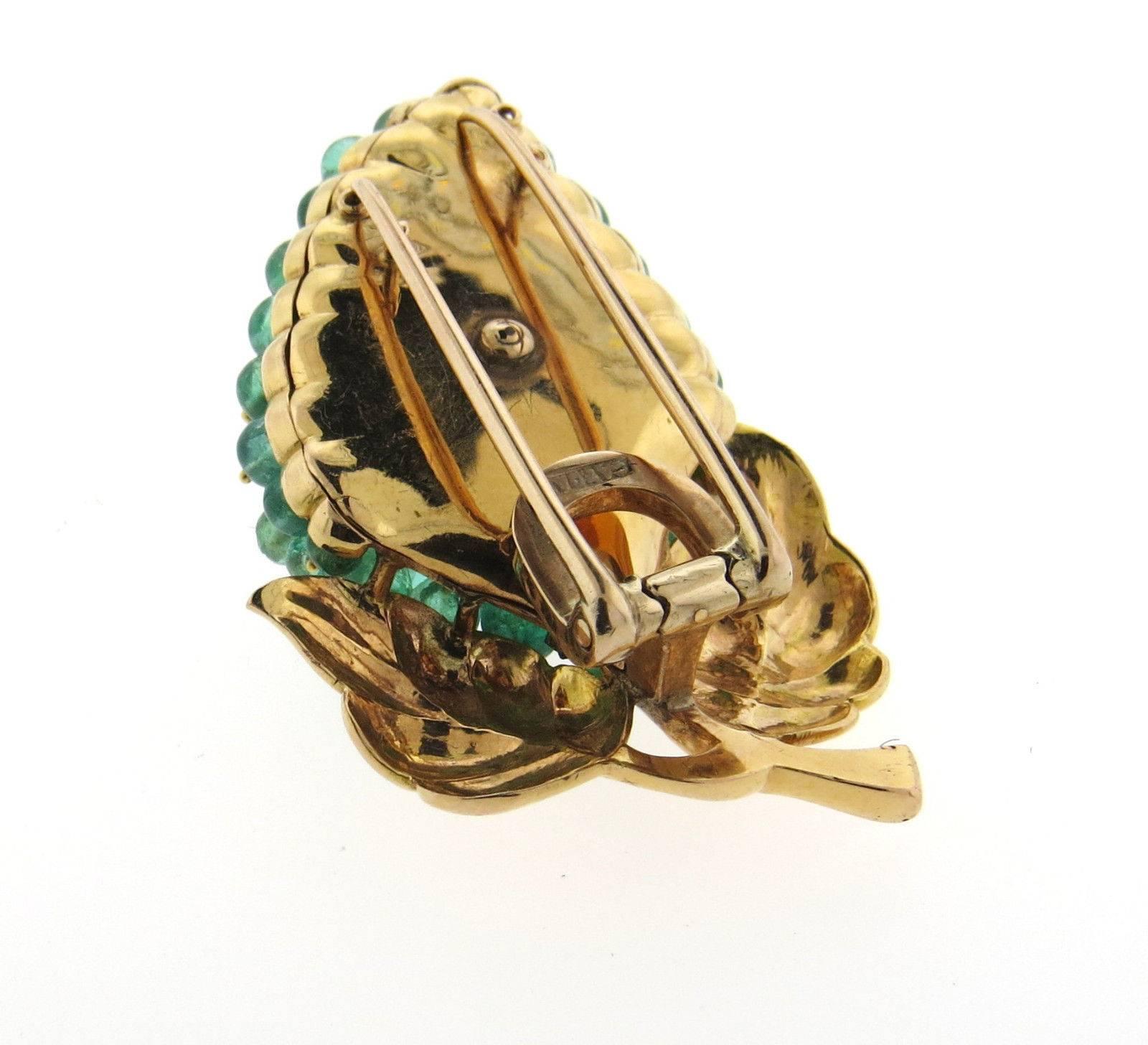 An 18k gold brooch set with emeralds and approximately 0.24ctw of G/VS diamonds. (*some emeralds have slight chips - visible upon close inspection*).  The brooch measures 54mm x 34mm  and weighs 26.4 grams. Marked: Gazdar 