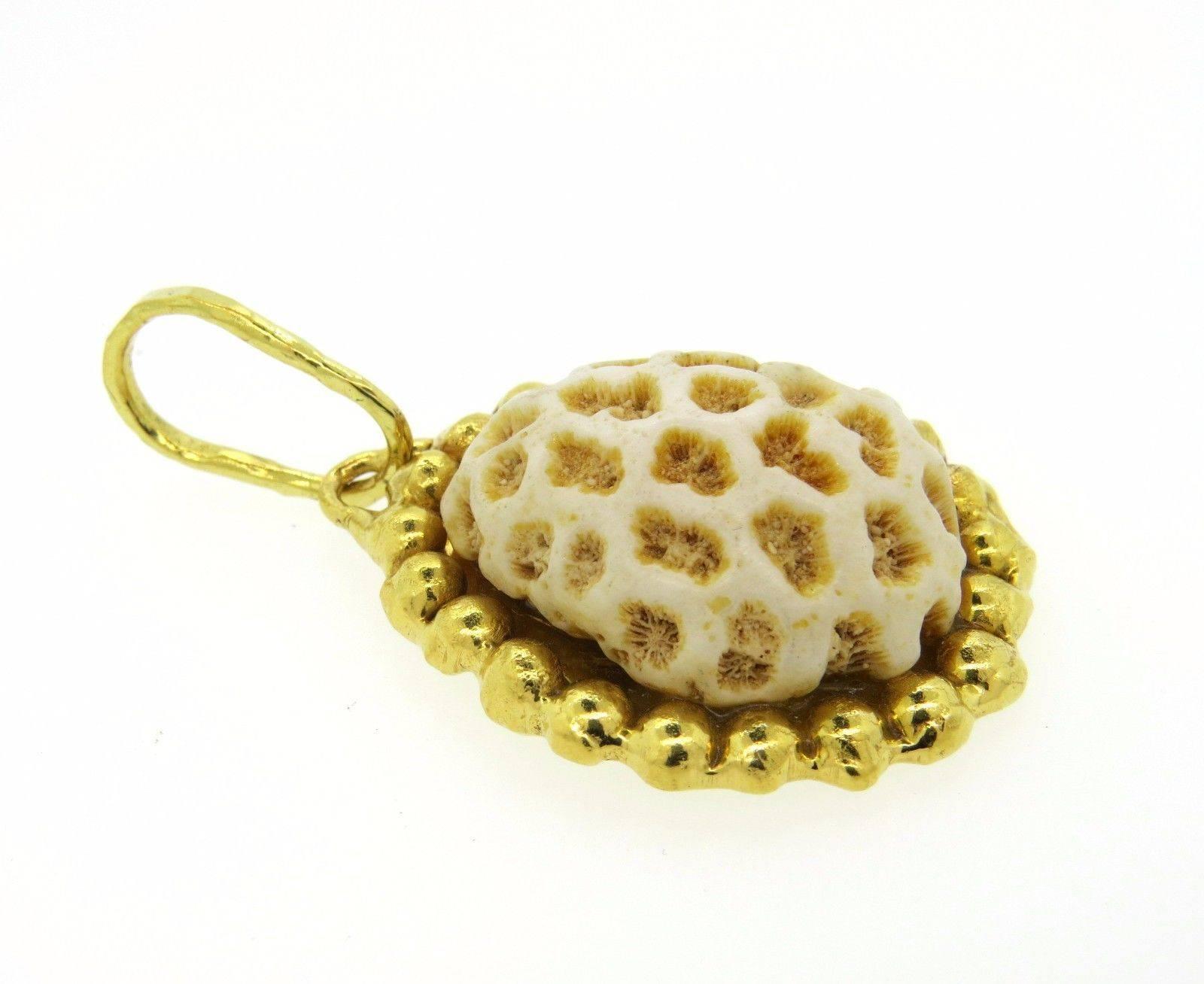 A 22k yellow gold pendant set with white coral. The pendant measures 67mm long (including bale) x 36mm at widest point.  The weight of the pendant is 40.7 grams.  Marked: Jean Mahie, 22K.