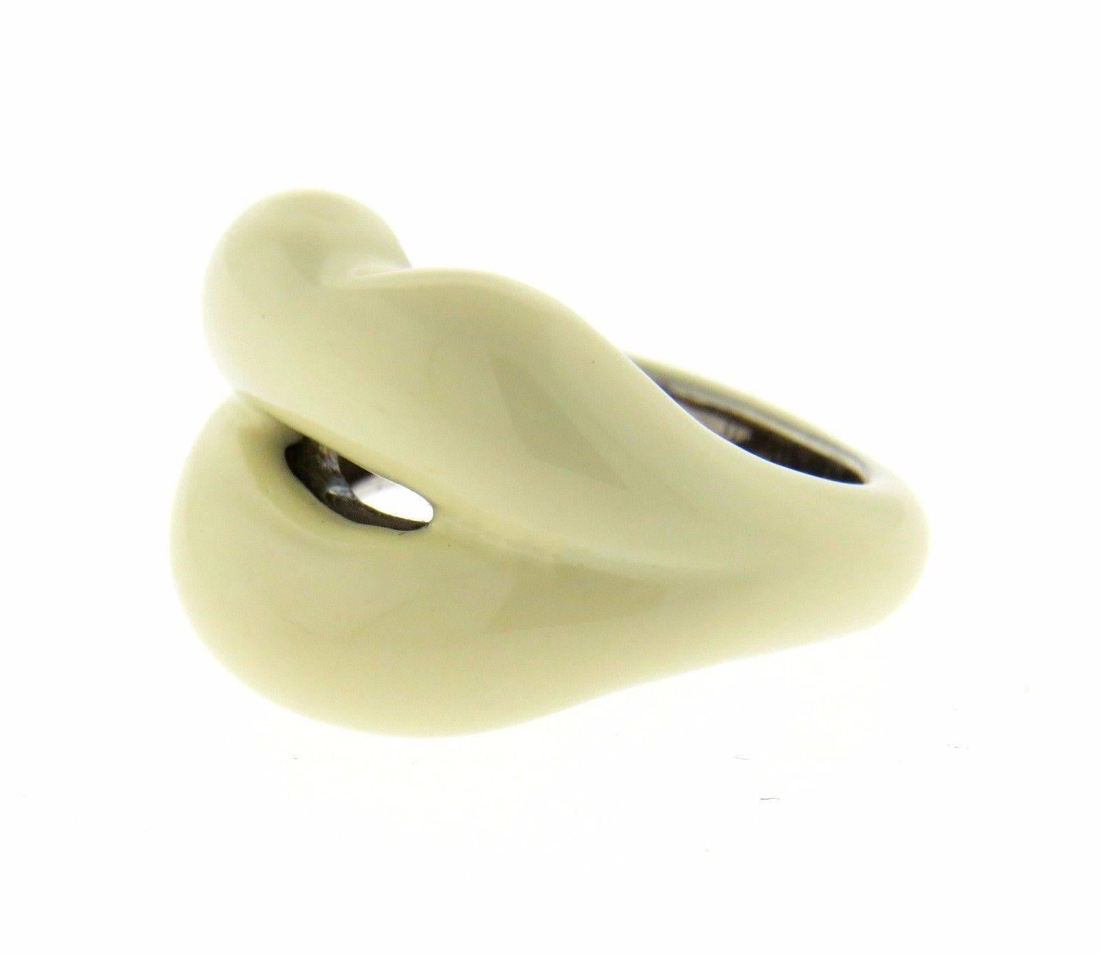 A Sterling Silver ring adorned with cream colored enamel.  The ring is a size 6.25, top measures 16mm at widest point.  The weight of the piece is 11.8 grams.  Marked: S-AP 925.