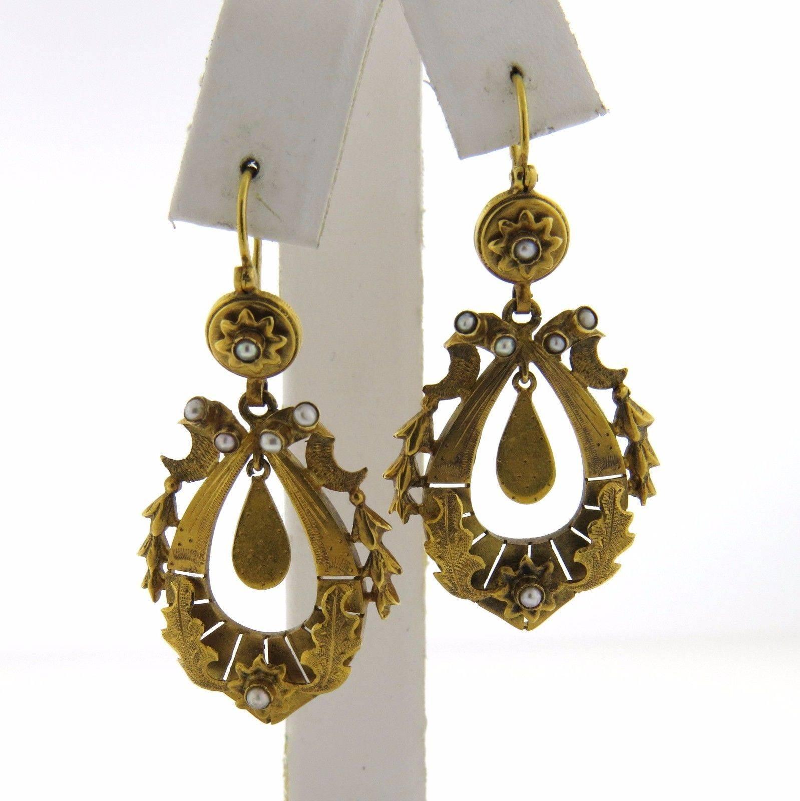 A pair of 15k gold earrings set with pearls.  The earrings measure 49mm (including wire) x 24mm and weigh 7 grams. Marked 15c.