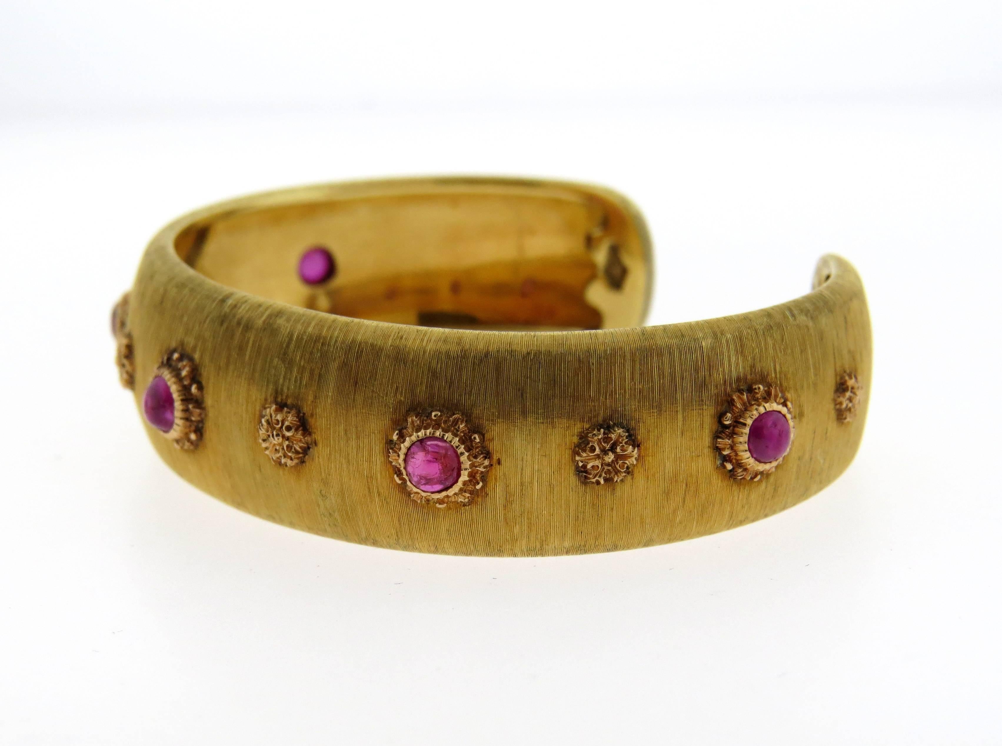 Magnificent 18K gold cuff by Buccellati featuring ruby cabochons. Cuff measures 16.1mm wide and will fit up to a 6.5