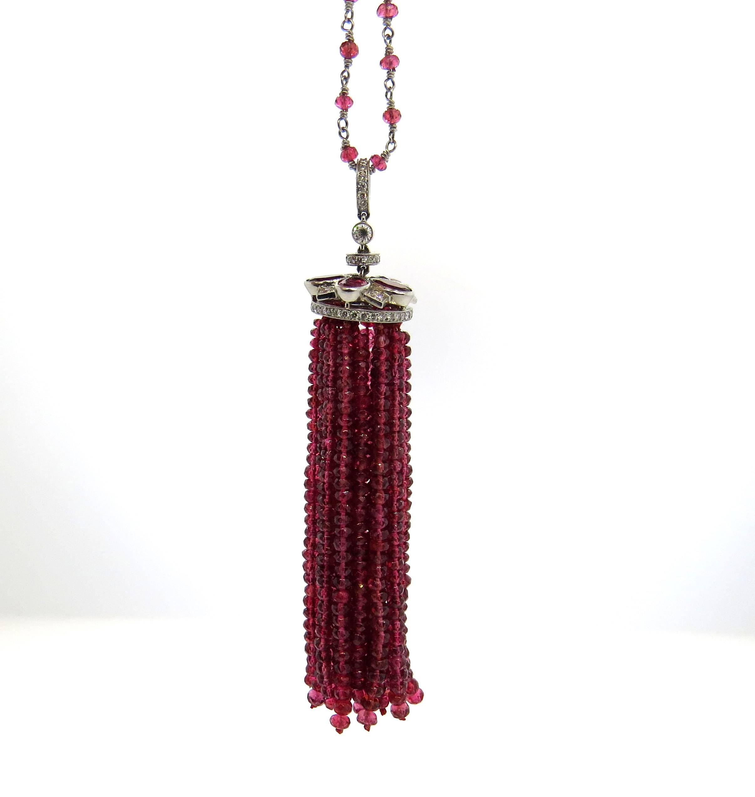 A platinum necklace set with red spinel and approximately 0.40ctw of G/VS diamonds.  The necklace is 24 3/4