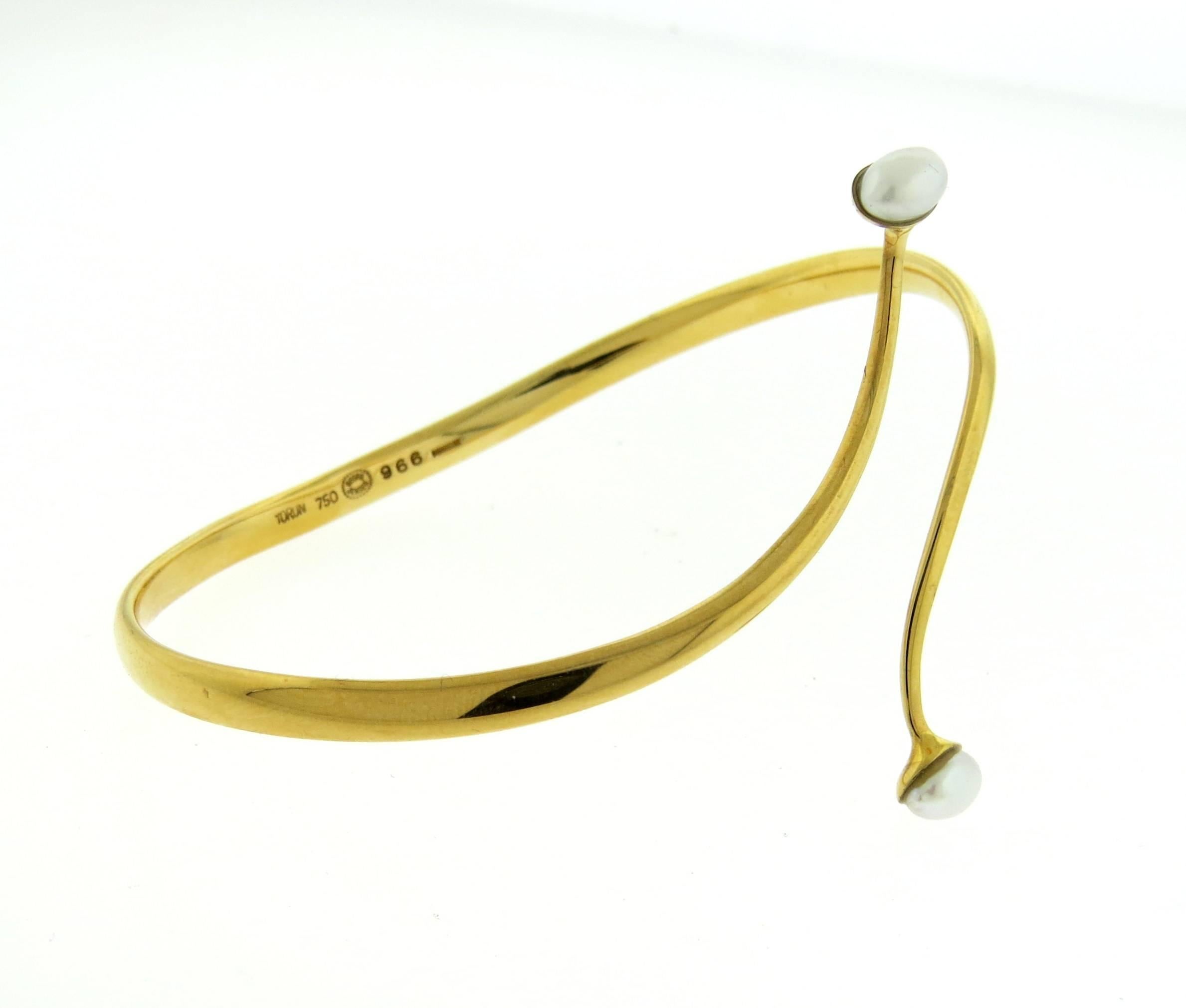 An 18k yellow gold bracelet set with pearls.  The bracelet will comfortably fit up to 7" - 7 1/2"  wrist and is 50mm wide  at center point.  The weight of the piece is 21 grams. Marked: Georg Jensen, 750, Denmark, 966 , Torun.  Comes with