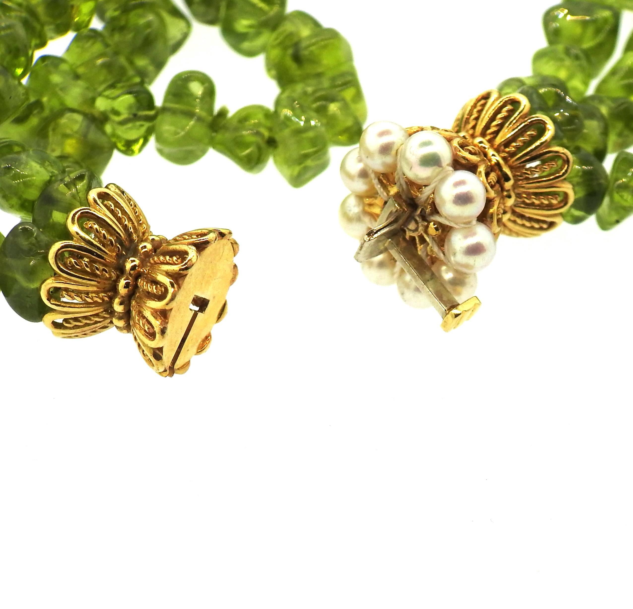 An 18k yellow gold necklace set with peridot beads and 4.3mm pearls.  The necklace measures 28