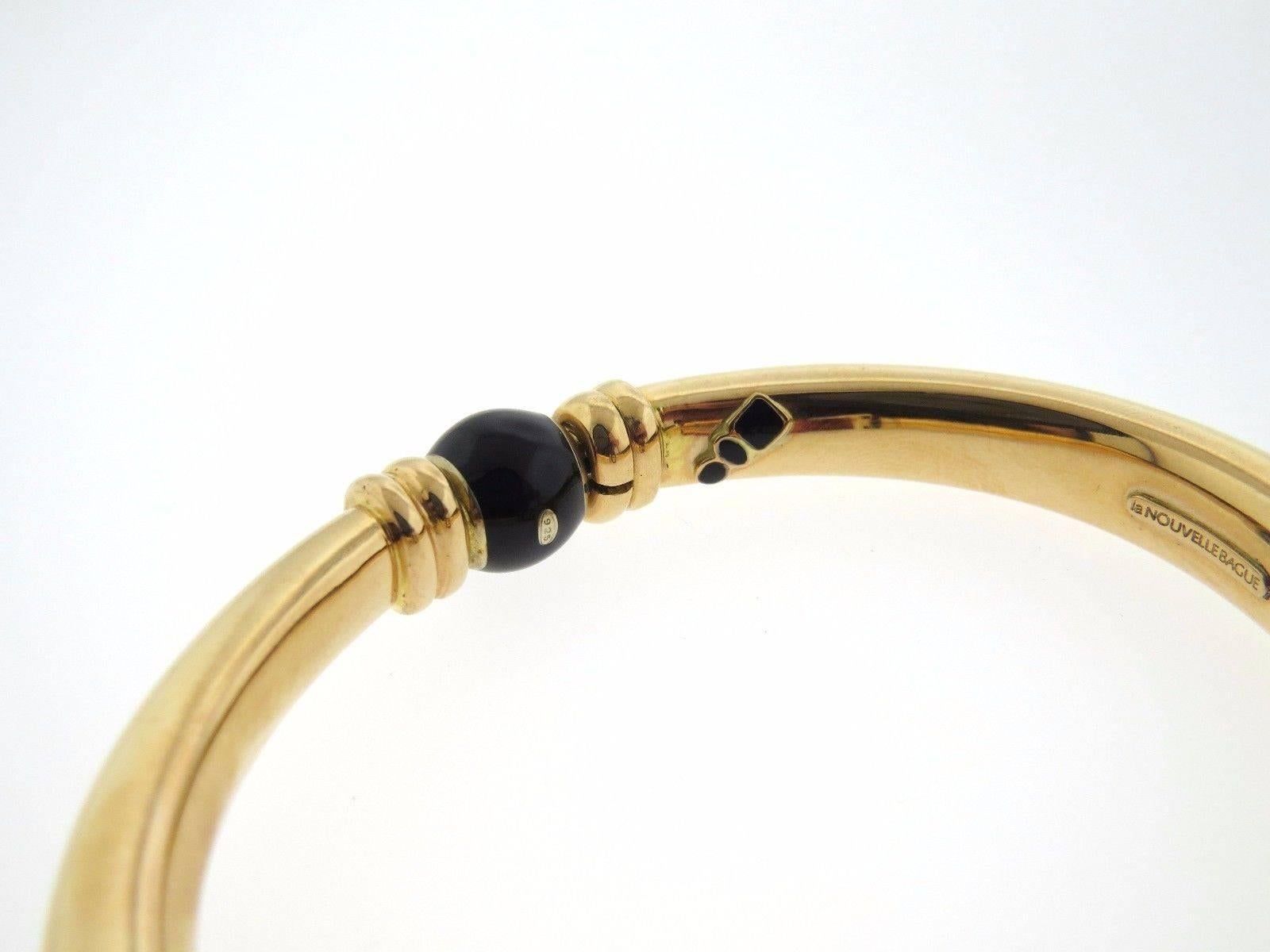 An 18k gold and sterling silver bracelet set with onyx and approximately 0.28ctw of H/VS diamonds.  The bangle will fit up to a 7.5
