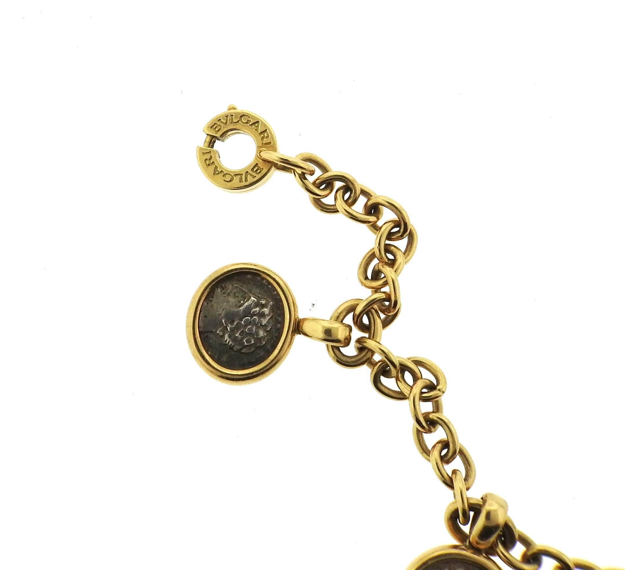 AN 18k yellow gold charm bracelet, crafted by Bulgari, featuring five ancient coins suspended charms. Bracelet is 7 1/2