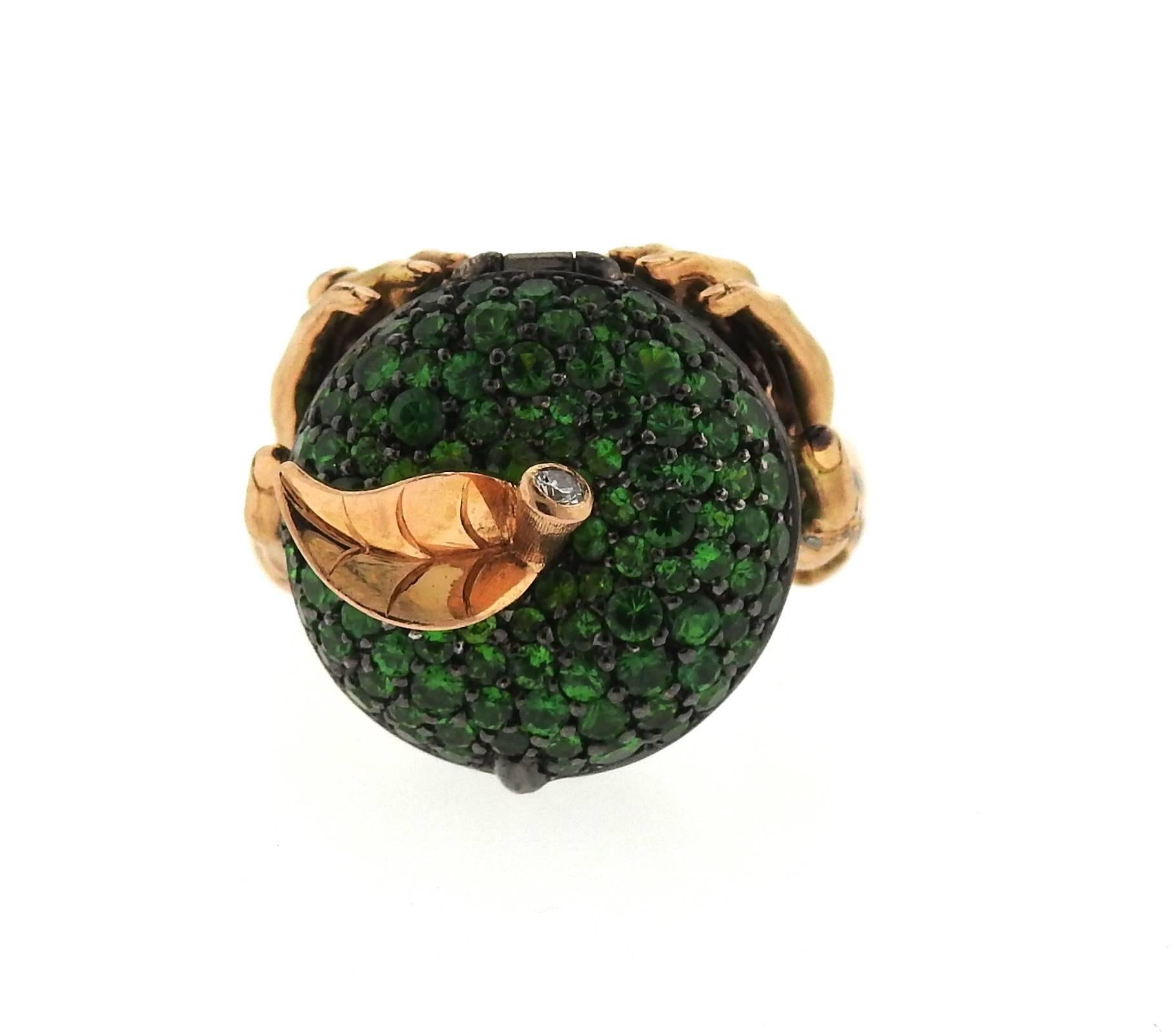An 18k rose gold poison ring, crafted by Stephen Webster, featuring opening apple, decorated with 3.99ctw in tsavorite garnets and approx. 0.11ctw in diamonds.  Ring size - 6, ring top is 20mm x 21mm, sits approx. 20mm from the finger. Marked: