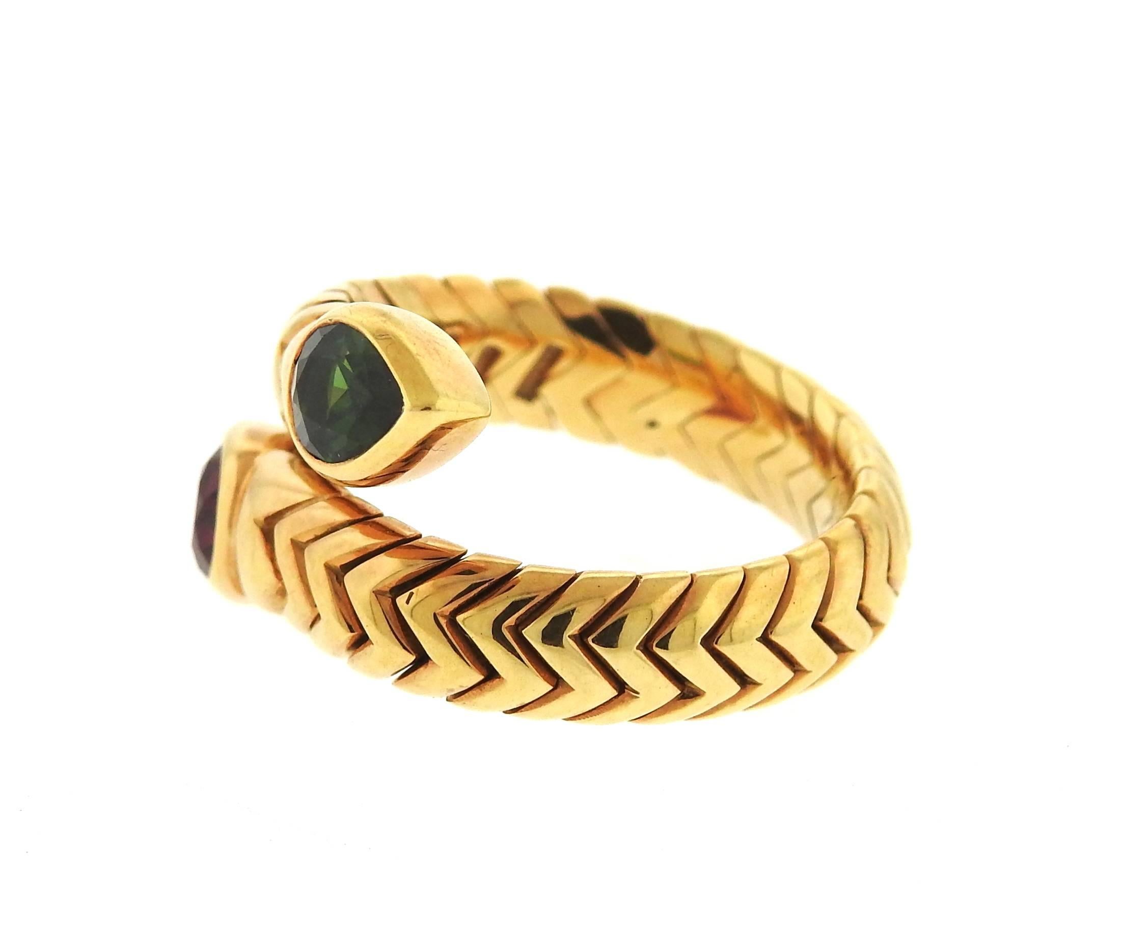 An 18K yellow gold ring set with a ruby and green tourmaline. The ring is a size 7 (slightly flexible due to construction of the ring) and is 14mm wide.  Marked: Bvlgari, 750, Italian marks.  The weight of the piece is 11.6 grams.