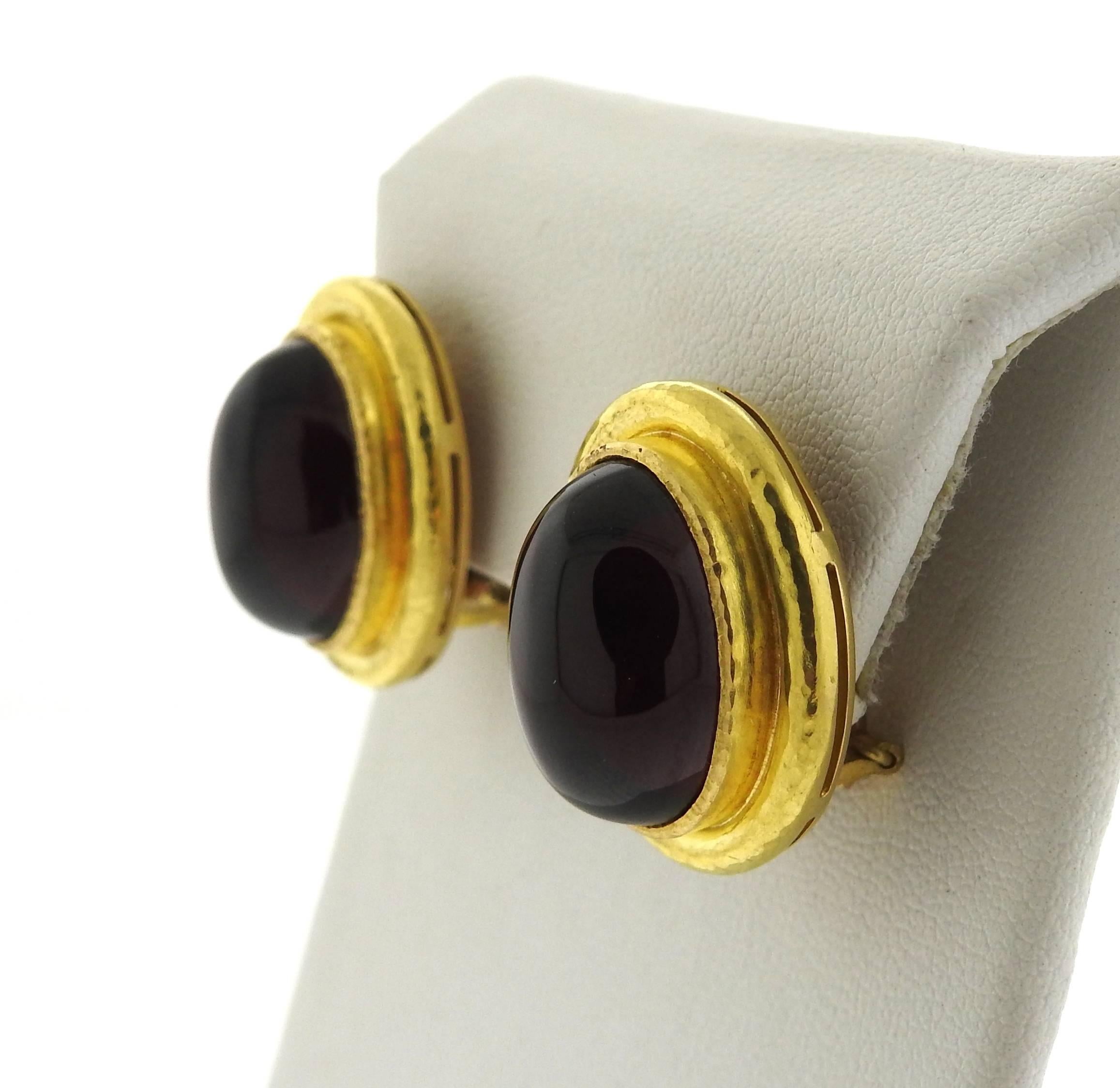 A pair of 18K yellow gold earrings set with oval garnet cabochons measuring 17.5mm x 12.5mm.  The earrings measure 23mm x 19.7mm and weigh 22.3 grams.