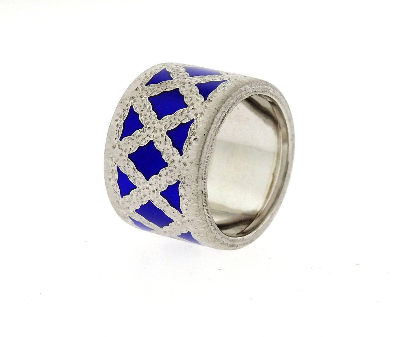A sterling silver ring adorned with blue enamel.  The ring is a size 7 and is 14.8mm wide.  Marked: Buccellati, Italy, 925.  The ring weighs 10 grams.