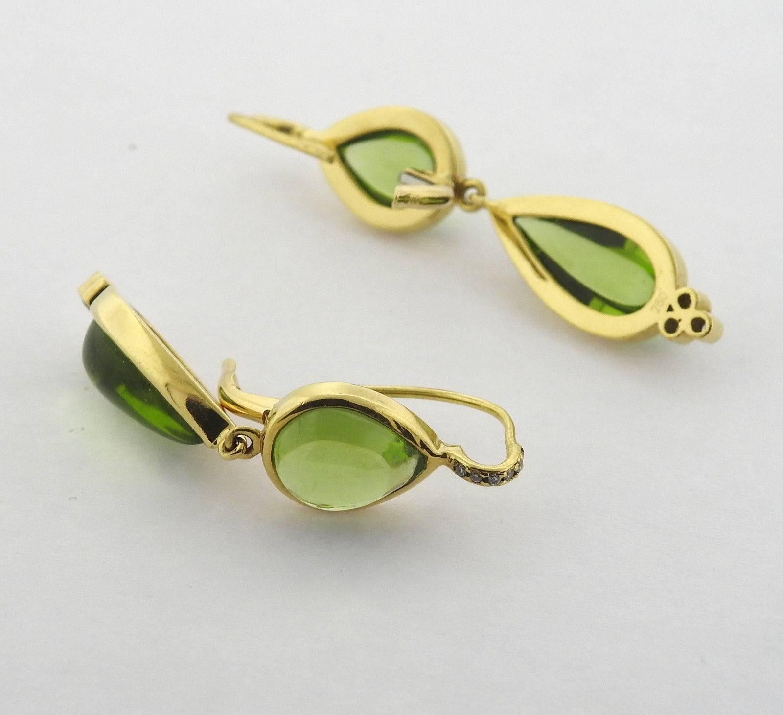 A pair of 18k yellow gold earrings set with peridot and approximately 0.15ctw of G/VS diamonds.  The earrings measure 45mm x 10mm and weigh 10.5 grams.  Marked with Temple Hallmarks, 750.  The current retail is $6900.