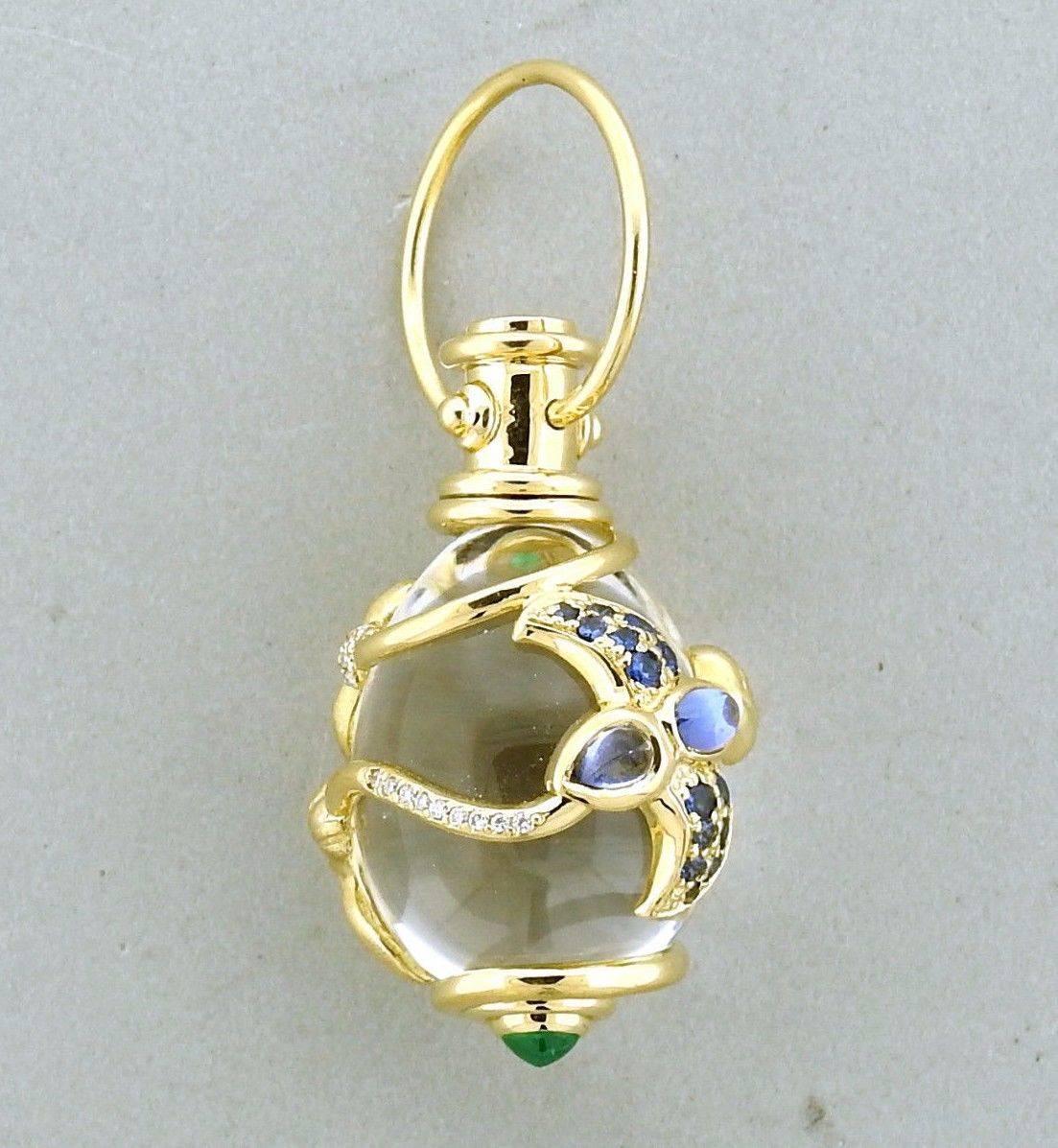 An 18k yellow gold crystal amulet pendant set with emeralds, tanzanite, sapphires and approximately 0.12ctw of G/VS diamonds.  The pendant without bale measures 35mm x 21mm, bale is 18mm in diameter.  The weight of the piece is 24.4 grams.  Marked: