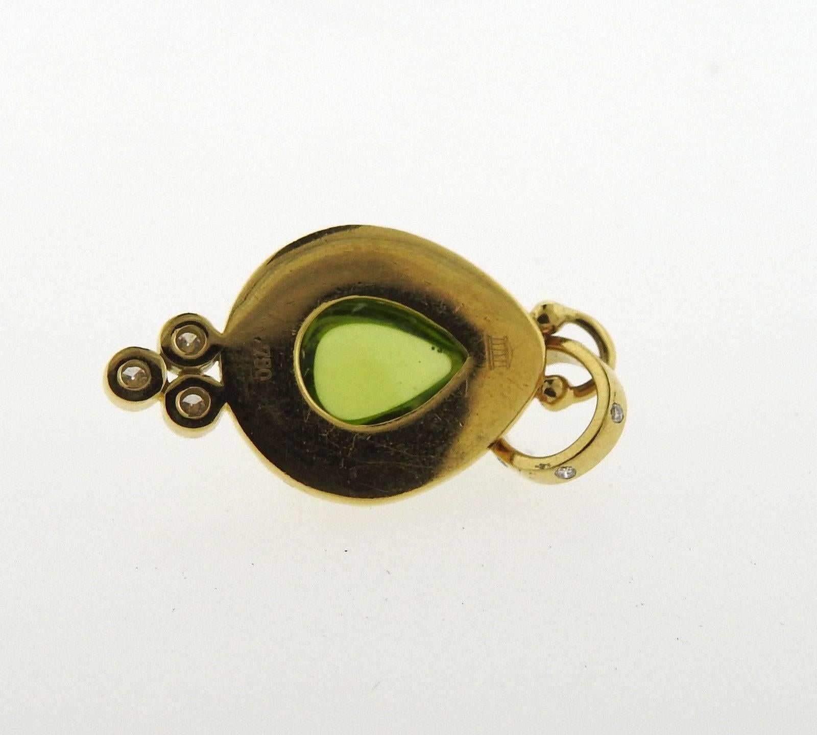 An 18k yellow gold pendant set with peridot and 0.35ctw of G/VS diamonds.  The pendant measures 30mm x 14mm and weighs 4 grams.  Marked: Temple mark, 750.  Current retail is $2700.