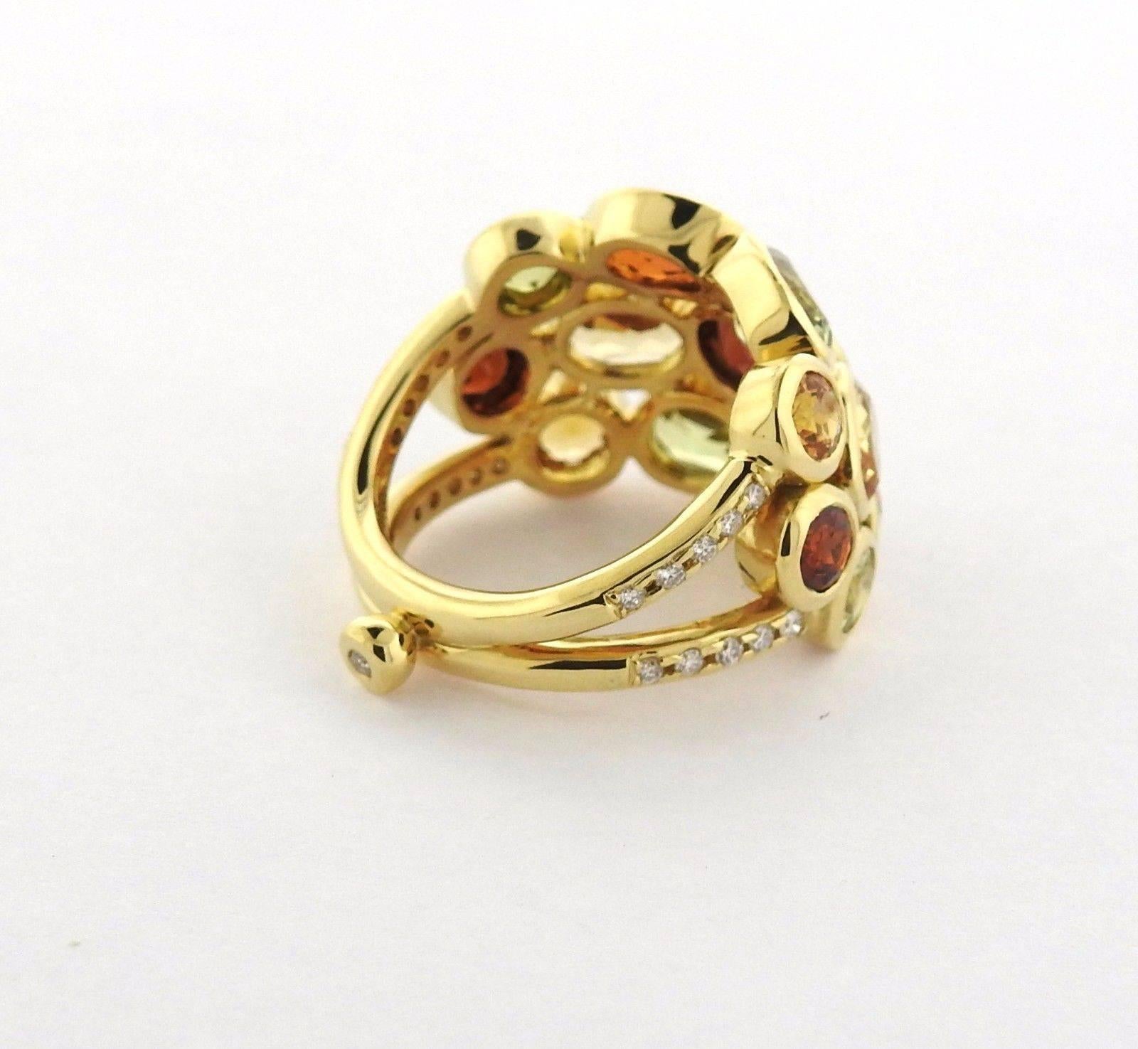 An 18k yellow gold ring set with rose cut mixed garnet and approximately 0.22ctw of G/VS diamonds.  The ring is a size 6.5, ring top is 17.6mm at the widest point.  The weight of the ring is 16.9 grams. Marked: Temple mark, 750.  The retail price of