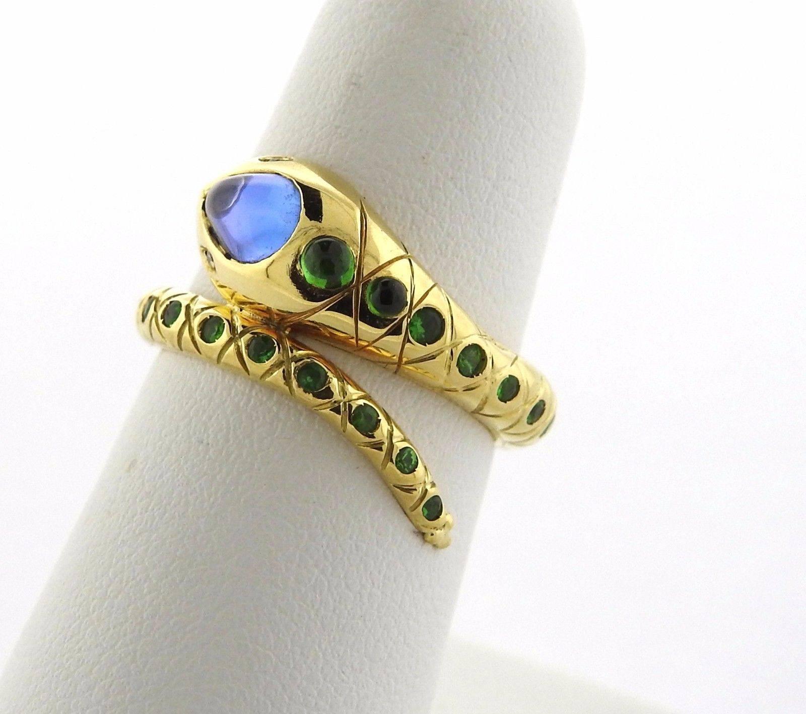 An 18k yellow gold serpent ring set with tanzanite, tsavorite and a diamond.  The ring is a size 6.25 Ring top is 10mm at widest point.  Marked: Temple Mark, 750.  The weight of the piece is 8 grams.  Retail is $3500.