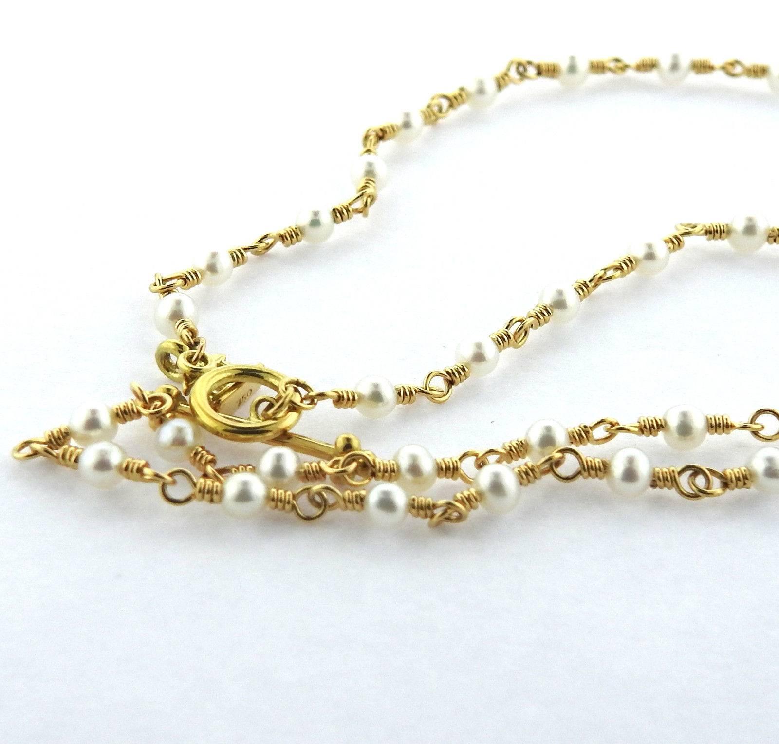 An 18k yellow gold necklace set with 3.5mm pearls.  The necklace is 18