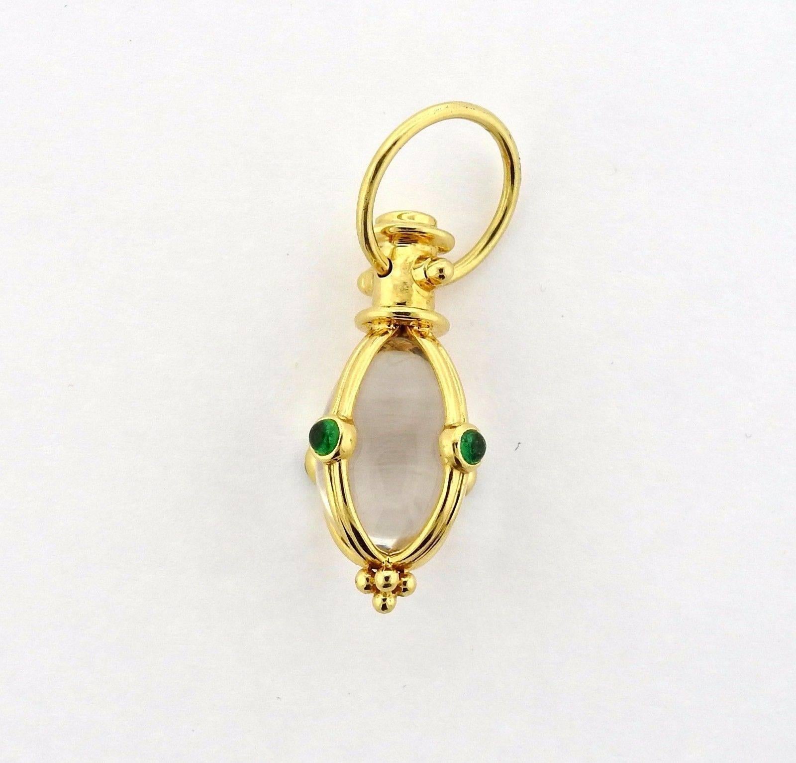 An 18k yellow gold rock crystal amulet set with emeralds. The pendant measures 38mm (including bale) x 16.4mm.  The weight of the piece is 8.2 grams. Marked: Temple Mark, 750.  The retail is $2100.