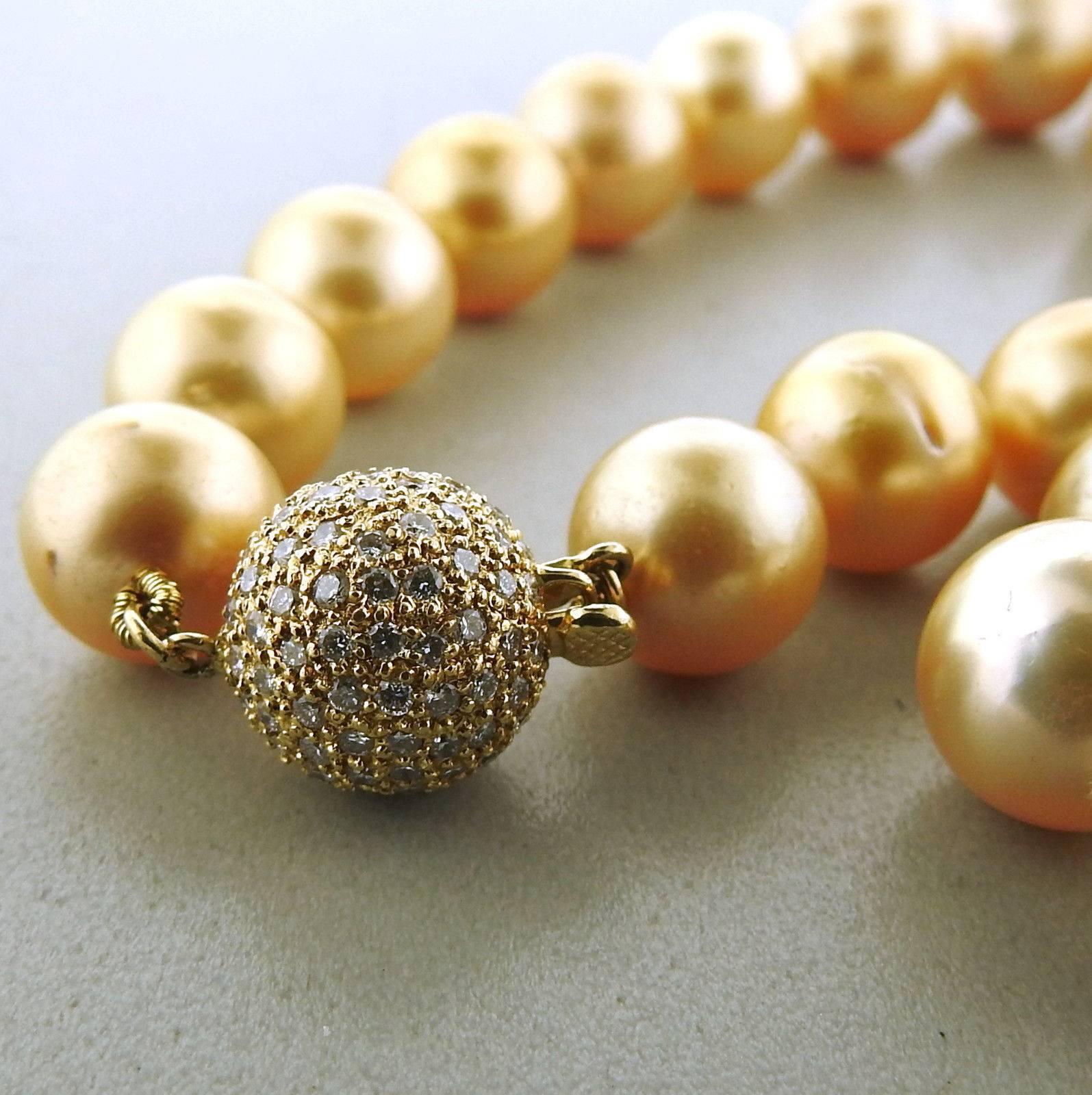 An 18k yellow gold necklace set with golden South Sea pearls measuring 10.5mm - 12.7mm in diameter and a diamond clasp.  The necklace is 20" long and weighs 83.7 grams. Marked: 750, 18k.