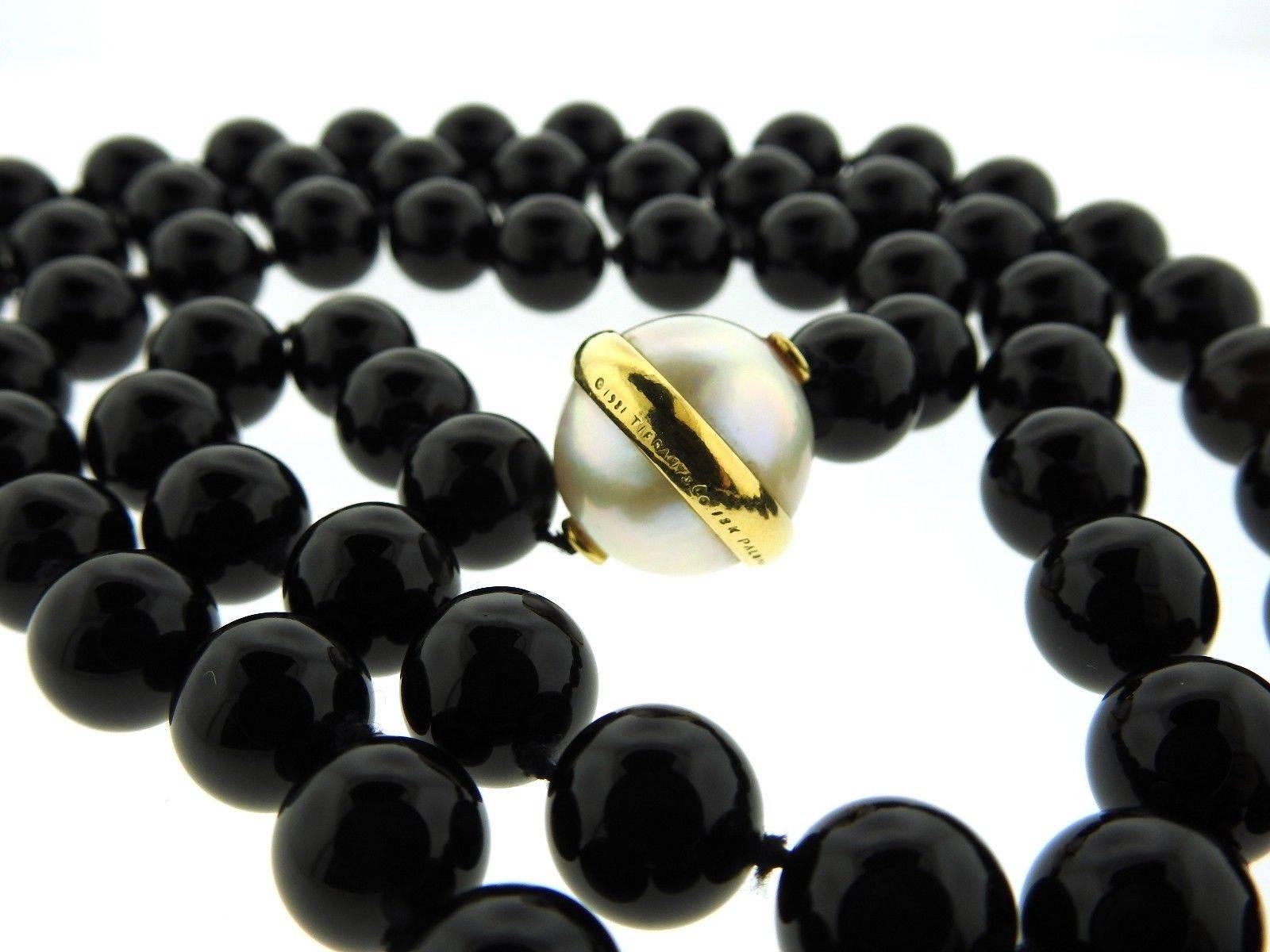 An 18k yellow gold necklace set with a 18.2mm pearl and 12mm onyx beads.  The necklace is 36