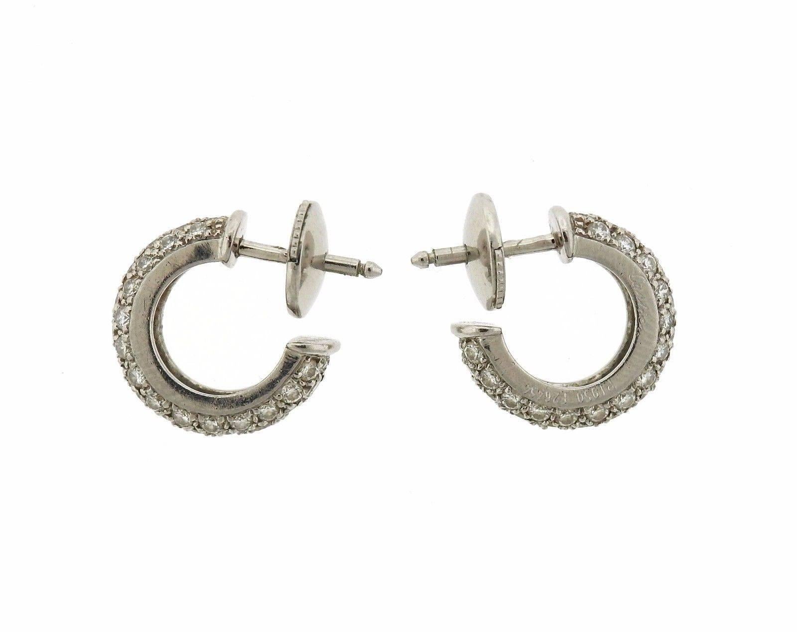 A pair of platinum hoop earrings set with approximately 1.26ctw of G/VS diamonds.  The earrings are 13mm in diameter and 3.8mm wide.  The weight of the earrings is 5.5 grams.  Marked: Cartier, pt950, 26454.
 Retail price $9600.